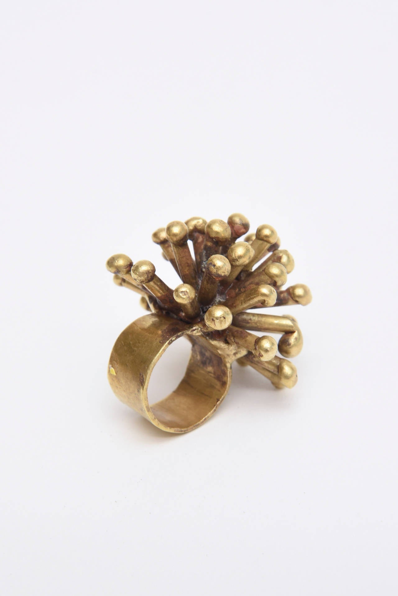 This bronze sculptural Sputnik ring has a studio feel to it. It is unsigned and has been attributed to the wonderful work of artist Pal Kepenes. It makes quite the statement. It has spokes going in all directions finished with rounded ball like