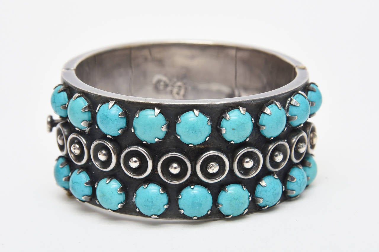 This gorgeous hallmarked mid century sterling silver and turquoise vintage cuff bracelet has dimensional sterling disks in between the 2 rows of turquoise. This is an early piece from the 40's. It is hallmarked 925 Taxco Mexico 3. This fits