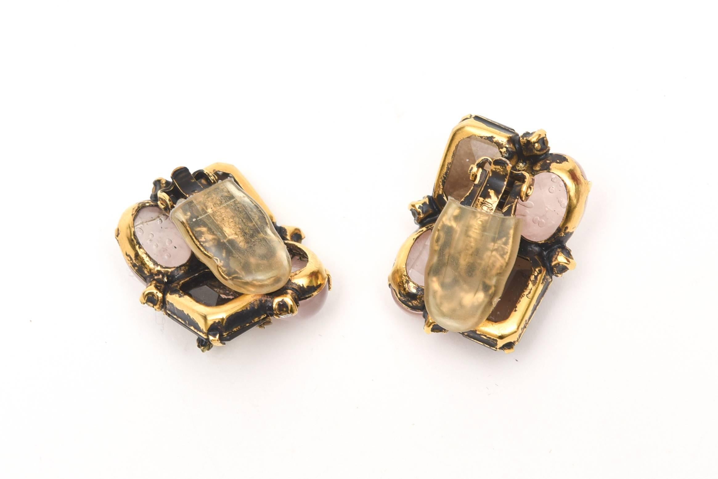 These stunning and beautiful pair of substantial clip on earrings are signed by Iradj Moini.The mix of dark to light rose quartz and smoky quartz is interspersed
with clear rhinestones in a flower form and and diamond like settings surrounding