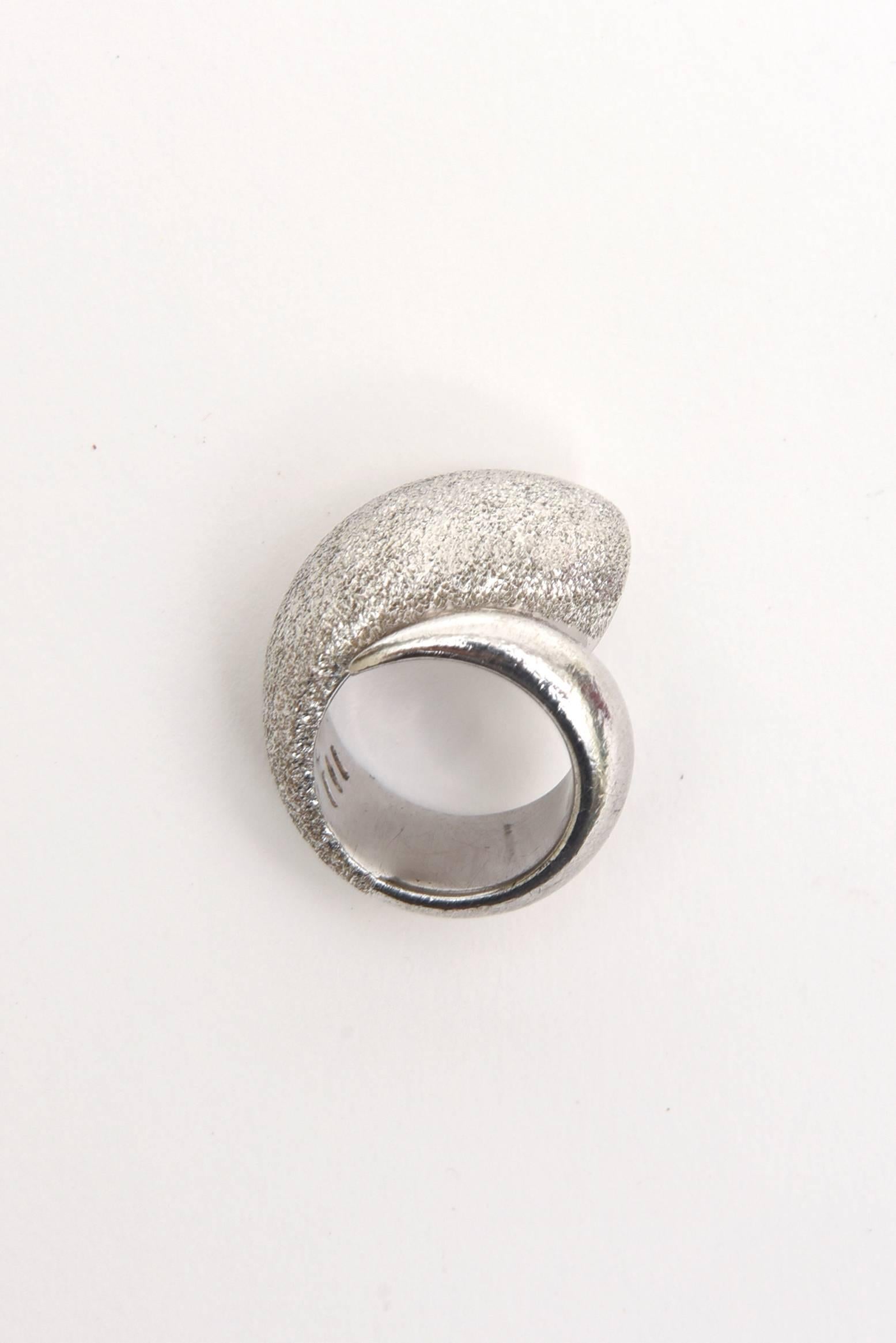  This Italian dome like ring is the combination of brushed sterling silver and polished sterling silver. in this sculptural ring it is from the house of Pianegonda. The brushed sterling looks like white gold. The width of the band in the back is