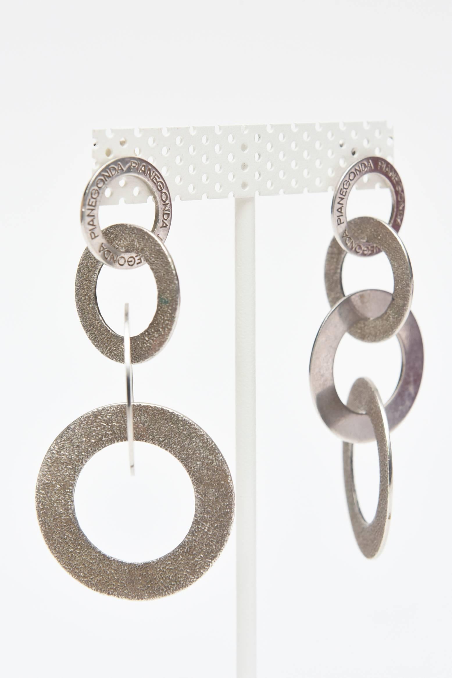 These sculptural Italian and marked four disc, two toned, sterling silver bangle earrings have texture versus polish.  The textural part is blackened Sterling Silver, and the other rings are a flat polish. They are much more interesting in person.