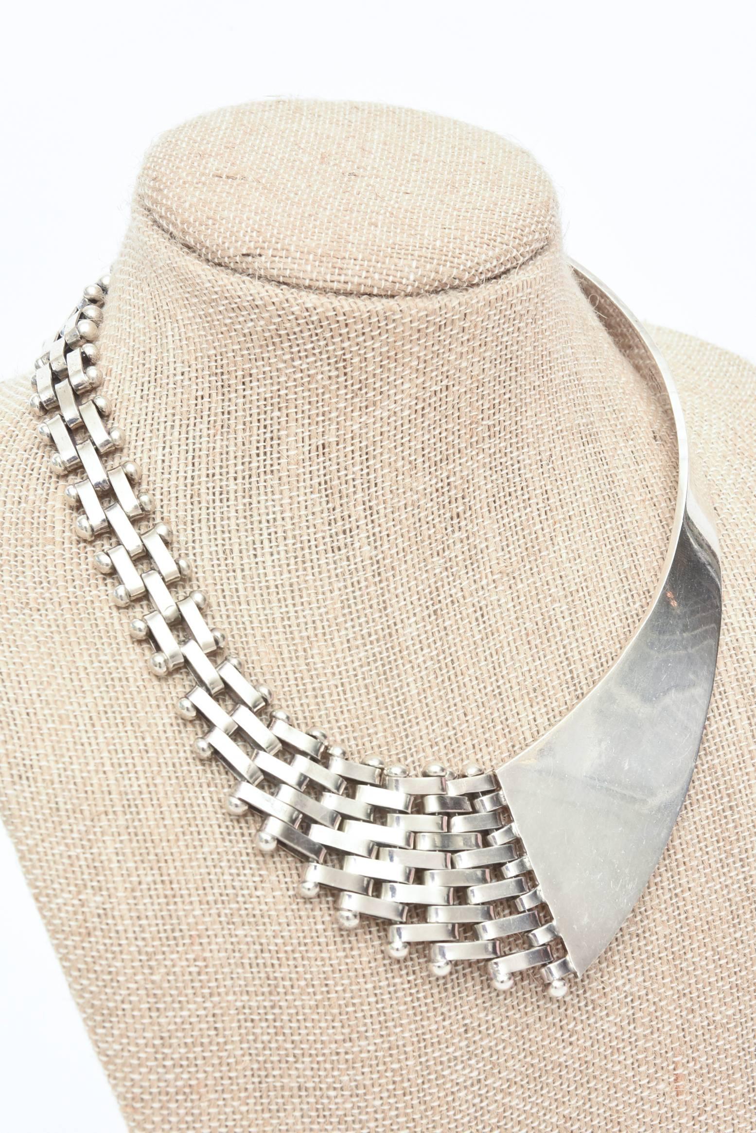 This handsome and sculptural Sterling Silver collar Necklace fits beautifully on the neck. 
The duality of the two sides; one with link and the other with polished sterling silver meet in the middle with a great combination.  The yin and the