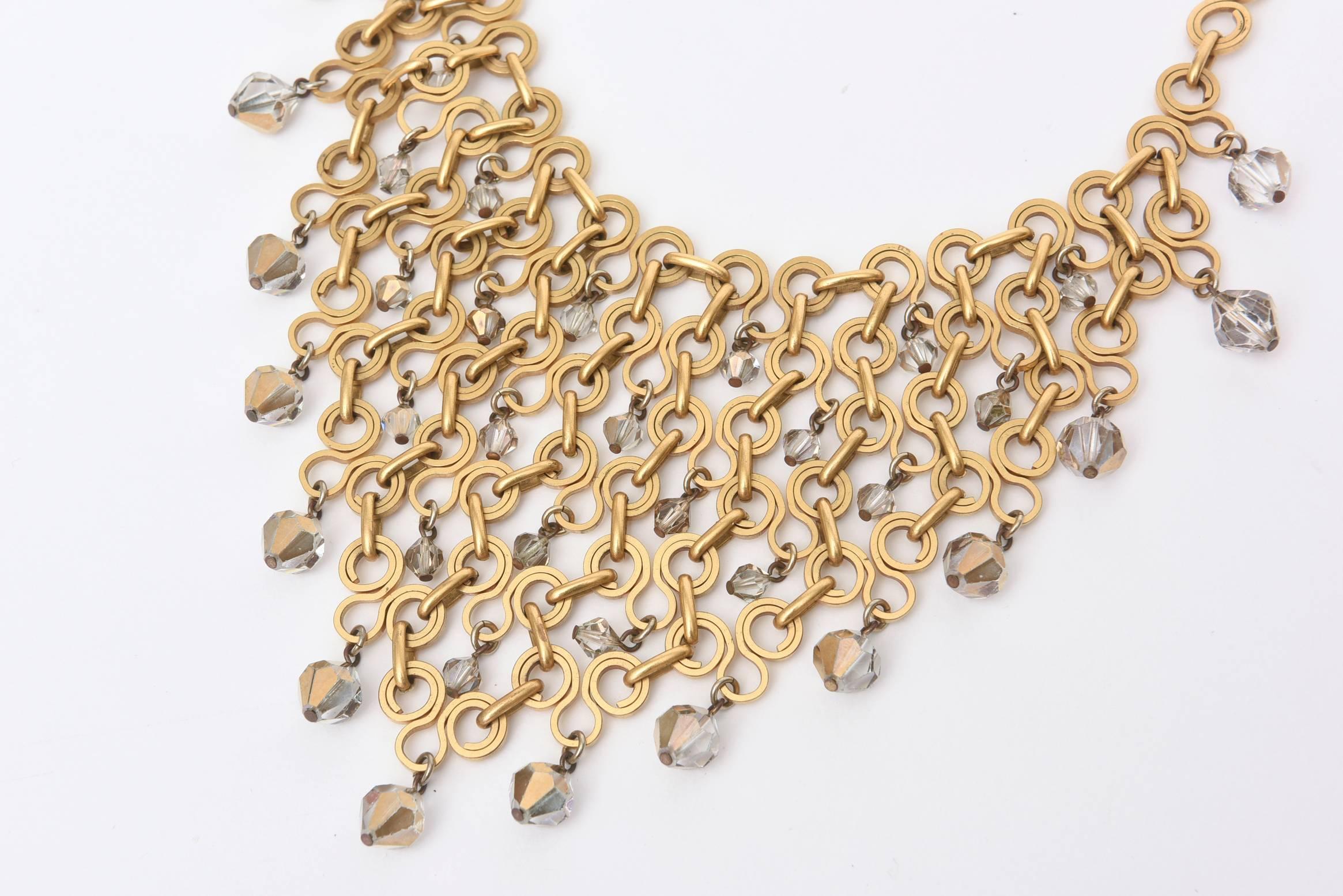 This wonderful french bib geometric necklace has been attributed to Paco Rabanne, but is not signed. The inter-connecting, geometric brass links are with with fine precision and the faceted crystals are Swarovski in gray to radiant clear glass.