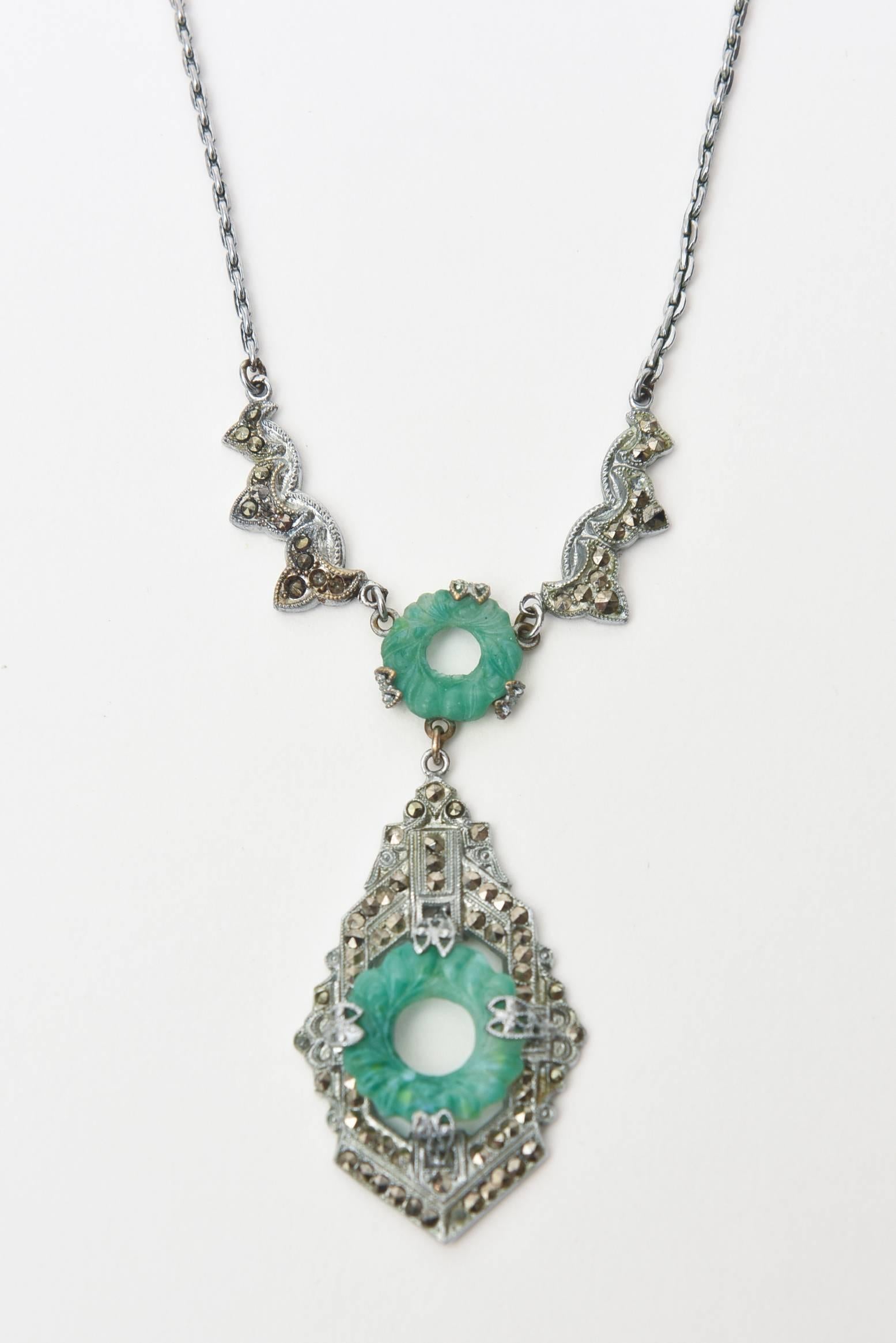 This lovely art deco necklace is made from a costume silver metal and has stone jade like life savers disks set in between the metal and marcasite. It is gorgeous on the neck and has a refined elegance. This is a keeper. The color of jade meets