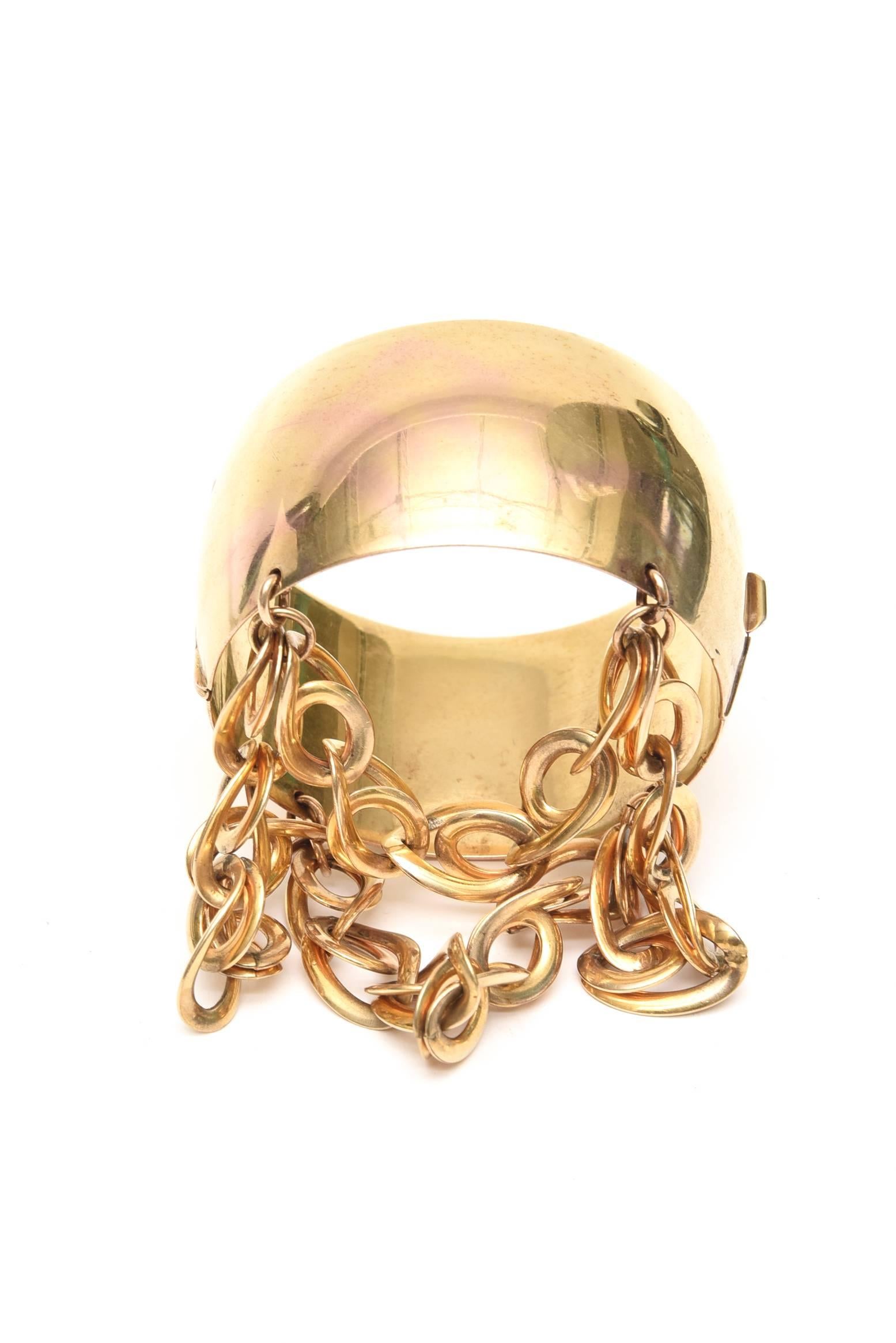 This unusual, chic, thick cuff bracelet w/ dangling link chain is gold wash over sterling silver.  IT IS vermeil.
The chains cascade beautifully on your hand. 
This is an unusual bracelet. It is modern and even rocker style with a more traditional