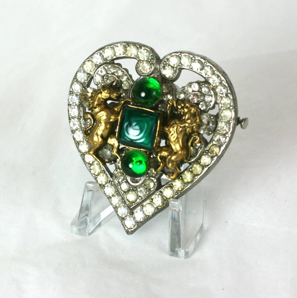 Coco Chanel Early Byzantine heart brooch, The silvered metal heart set with crystal pastes and appliqued with faux emerald hand formed pate de verre rounds and square jelly cut stones. 
Flanked by rearing gilt lion and unicorn, Coco Chanel