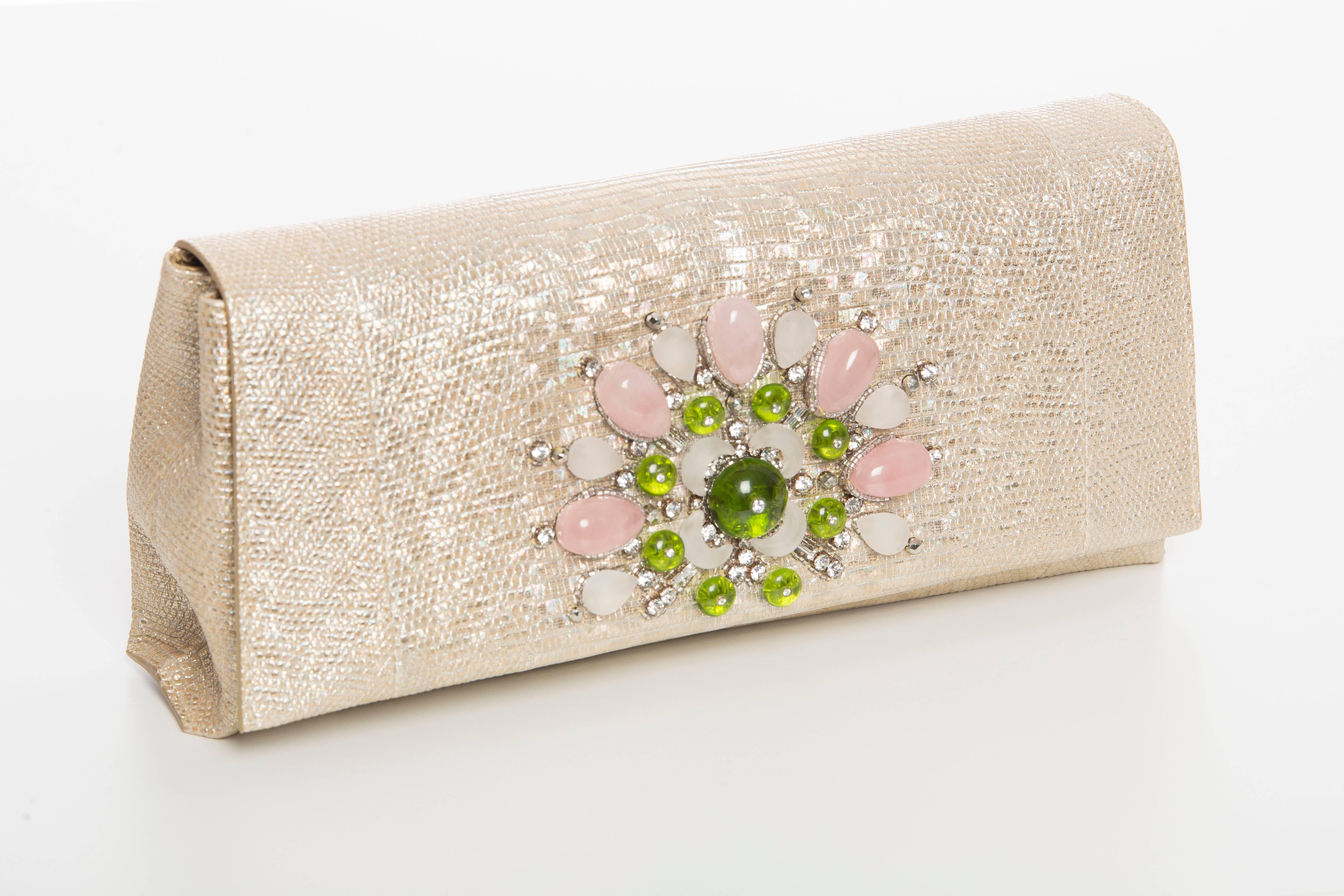 Bvlgari, Spring-Summer 2014, metallic lizard evening clutch with multicolor gem stones at front face, pink satin lining, single pocket at interior wall and snap closure at front flap. Includes dust bag

Retail: $5000.00

Height 5”, Width 10.5”,