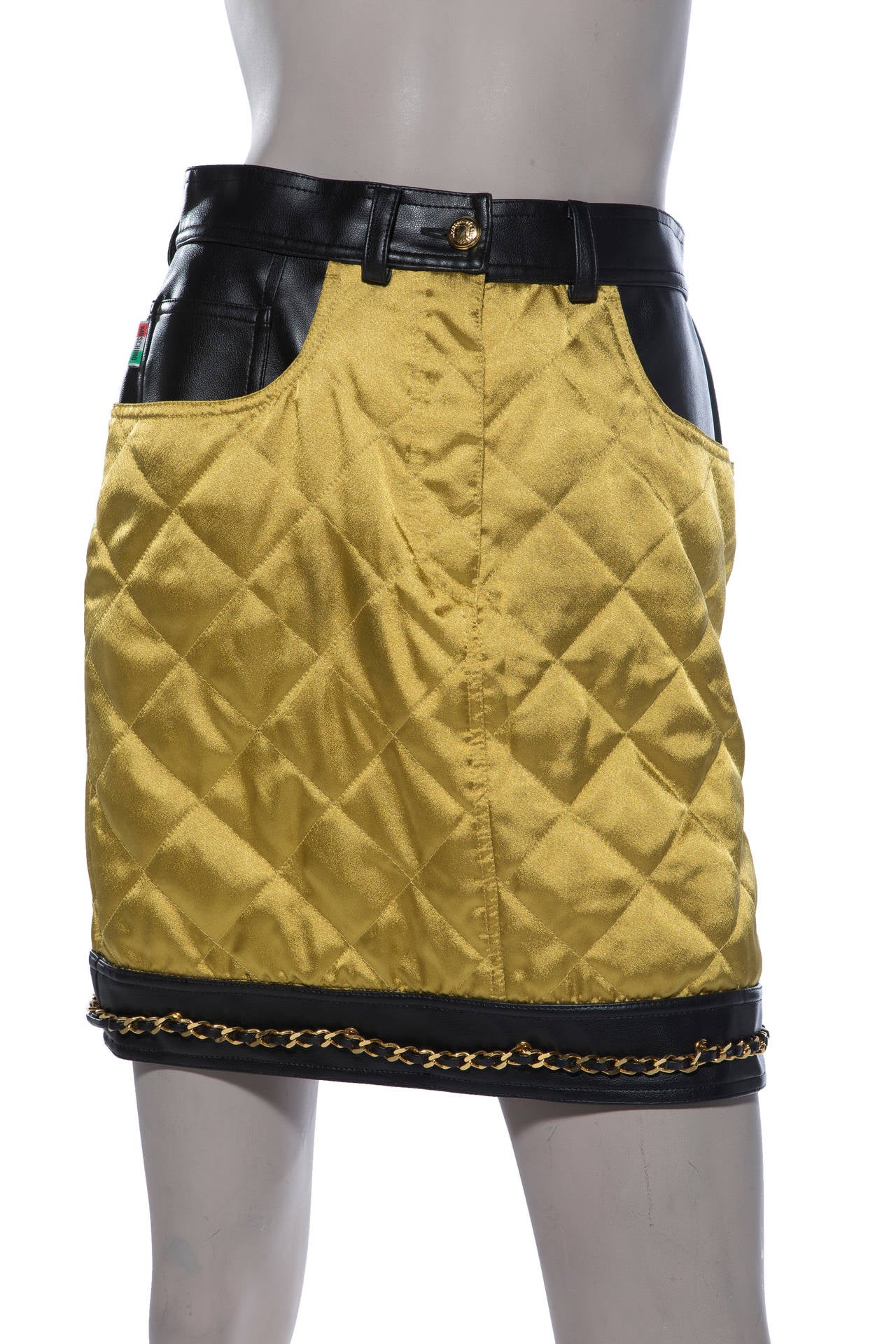 Moschino gold quilted satin skirt with black leather trim,chain detail and fully lined.