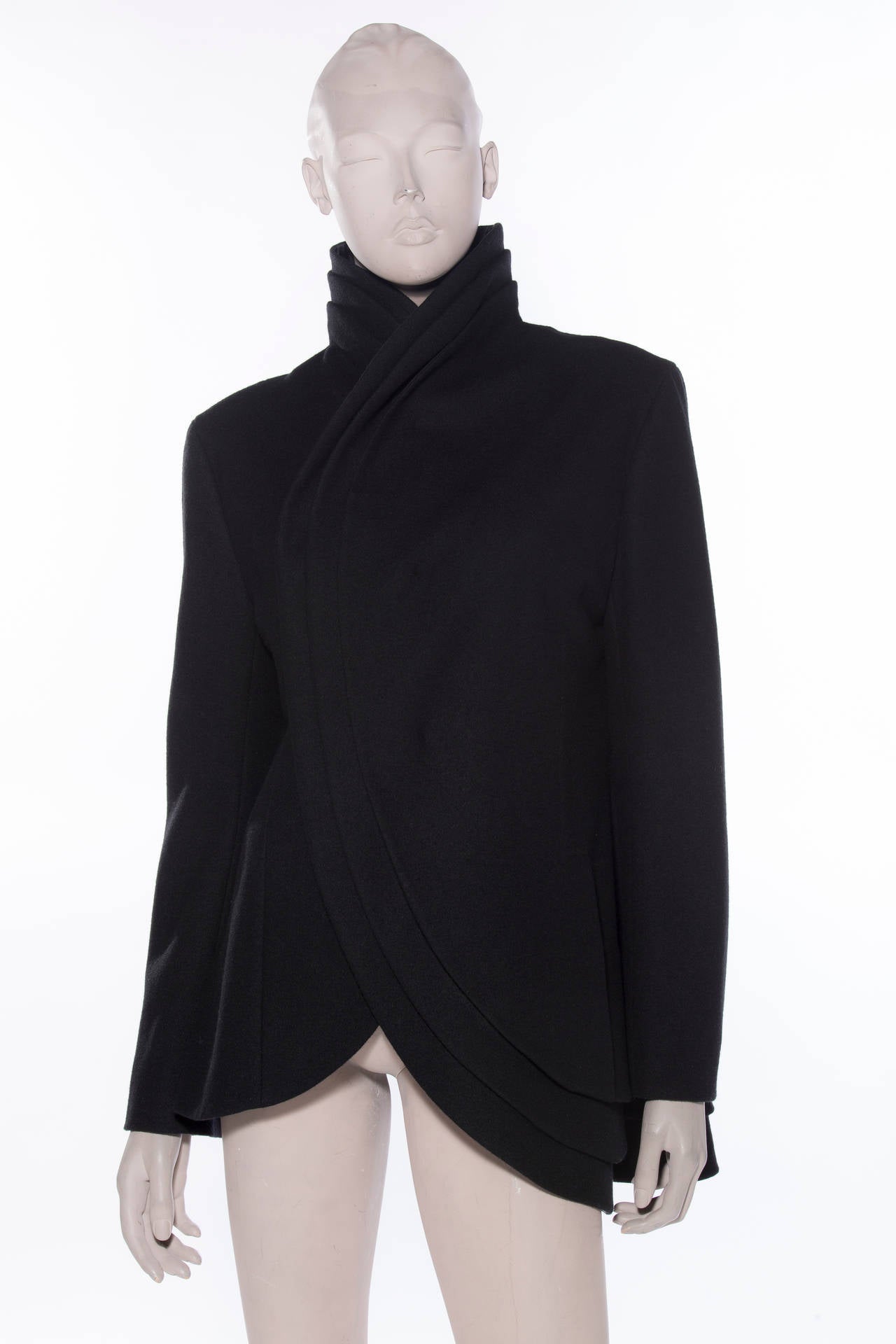 Yohji Yamamoto, circa 1980s, black wool jacket with stand collar, tiered edges, front welt pocket at waist and front concealed snap closure.

Bust 40”, Waist 37”, Shoulder 17”, Length 31.5”
Fabric Content: 90% Wool, 10% Nylon; Lining: 100% Cupro