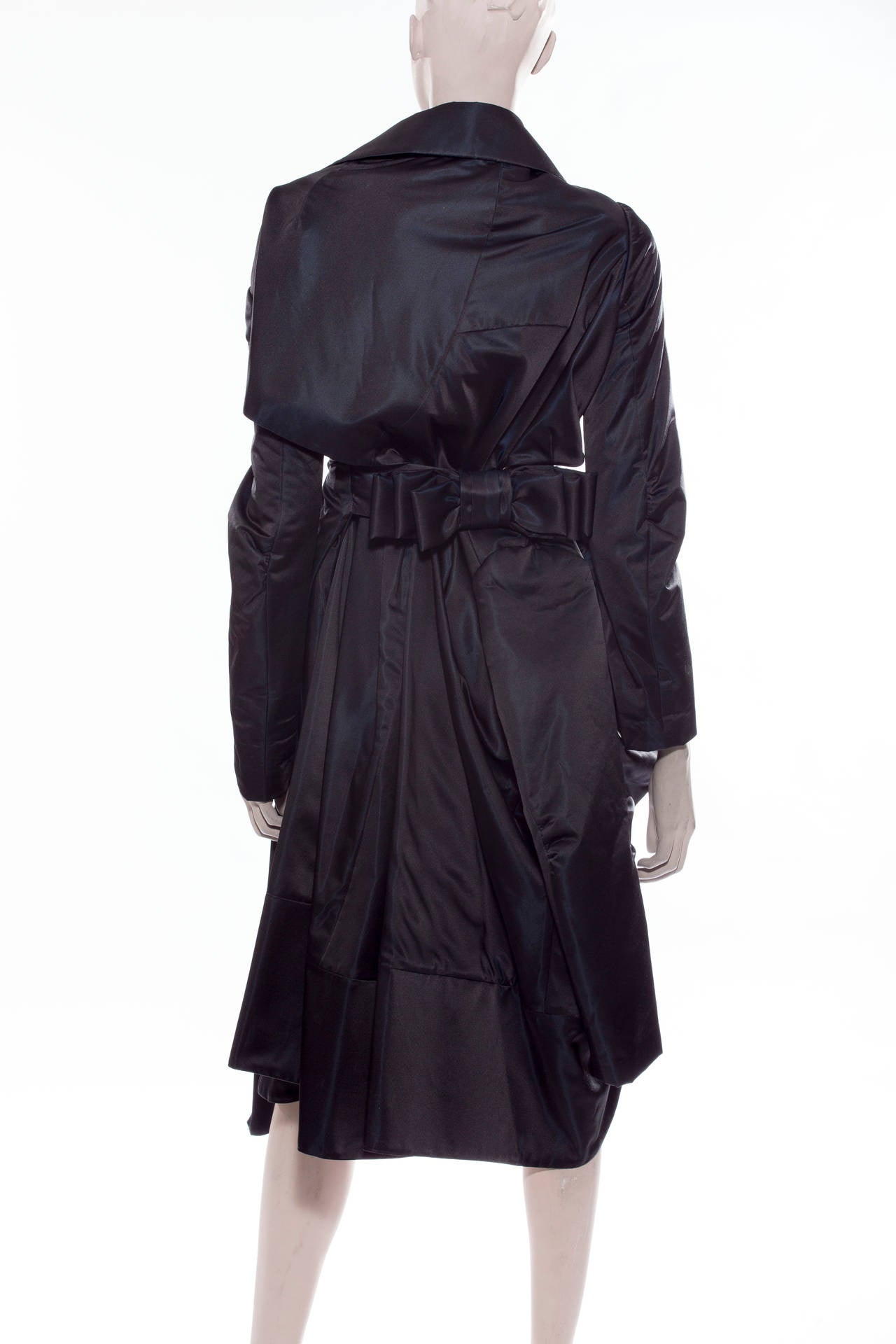 Commes des Garçons, Autumn/Winter 2004, black coat with long cuffed sleeves, slits at waist, cut outs featuring bow at center back, peter pan collar and hook and eye closures at center front.
Bust 40