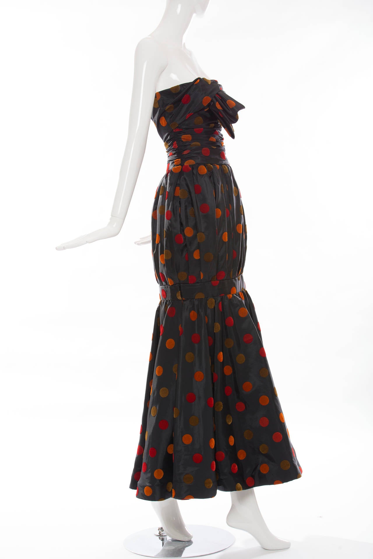 Nina Ricci, circa 1980's  bow front strapless taffeta velveteen dots evening dress with shirred waist, trumpet skirt with back zip and fully lined in silk.

EU. 38, US: 2
Bust: 29, Waist: 26, Hips: 37, Length: 51