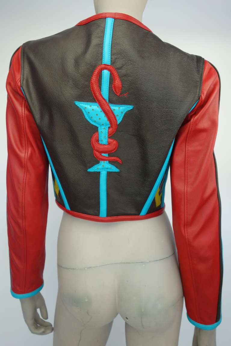 Jean Paul Gaultier Spring Summer 1991 leather jacket with shaped perforated leather breast cups,cage like ribs to the sides, zip front, chocolate brown and turquoise banding, serpent and chalice appliqué to the back and fully lined.

Part of the
