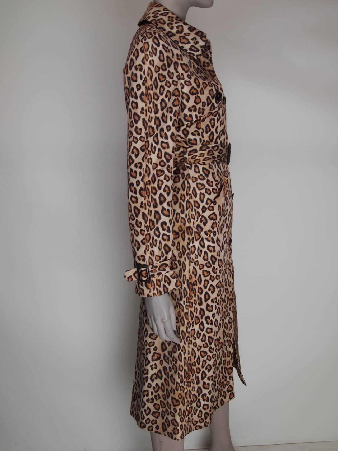 Alexander McQueen leopard print silk trench coat with removable belt, two front pockets, inverted pleat at back and front button closures.