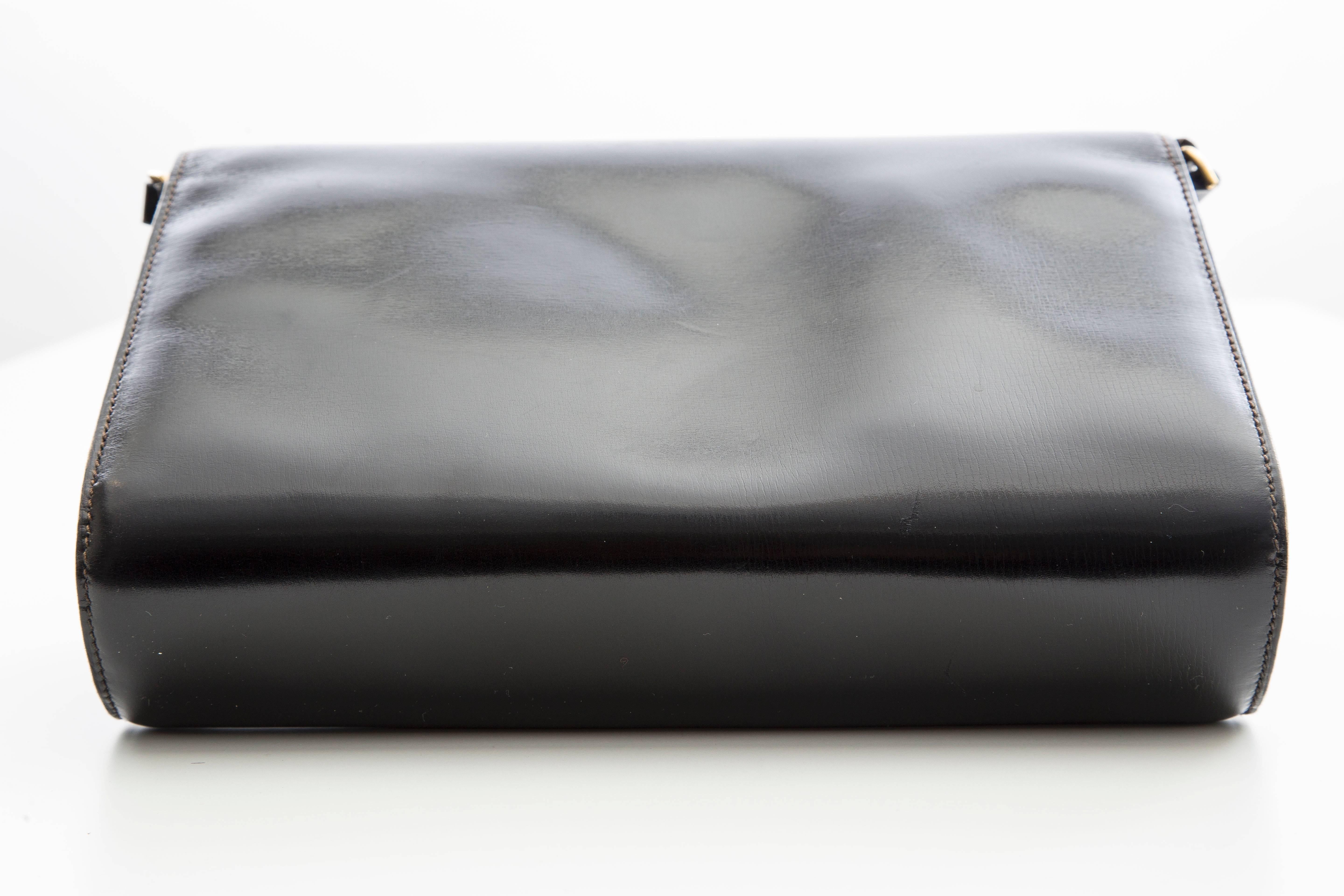 Gucci, circa 1970's, black leather clutch, interior pocket with detachable shoulder strap.

Serial Number: BO74