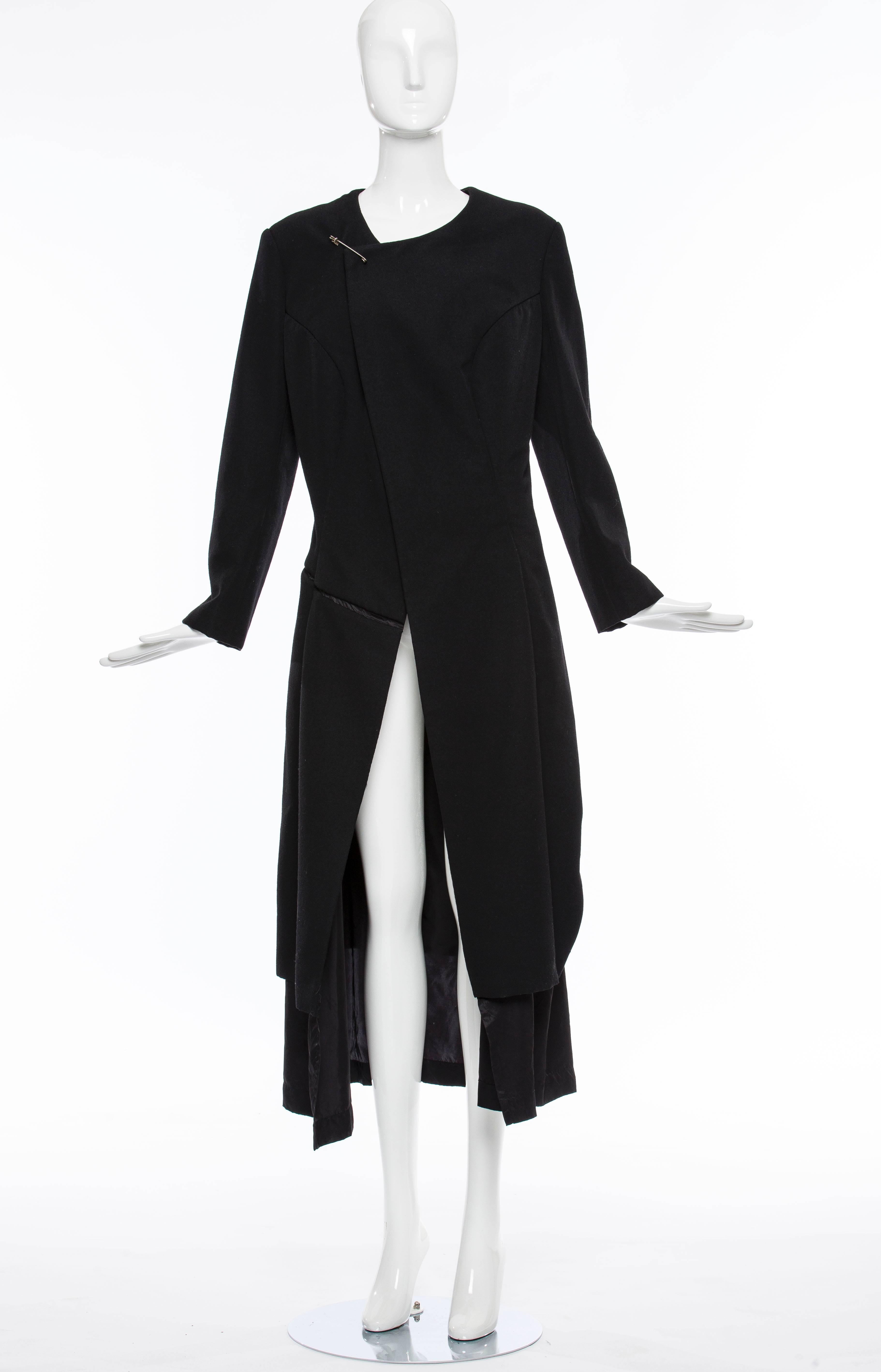  Comme des Garçons, circa 1997 black wool coat with asymmetrical neckline, long sleeves, tonal stitching throughout and safety pin closure at front.

Bust 38”, Waist 33”, Shoulder 17.5”, Length 45.5”, Sleeve 28.5”