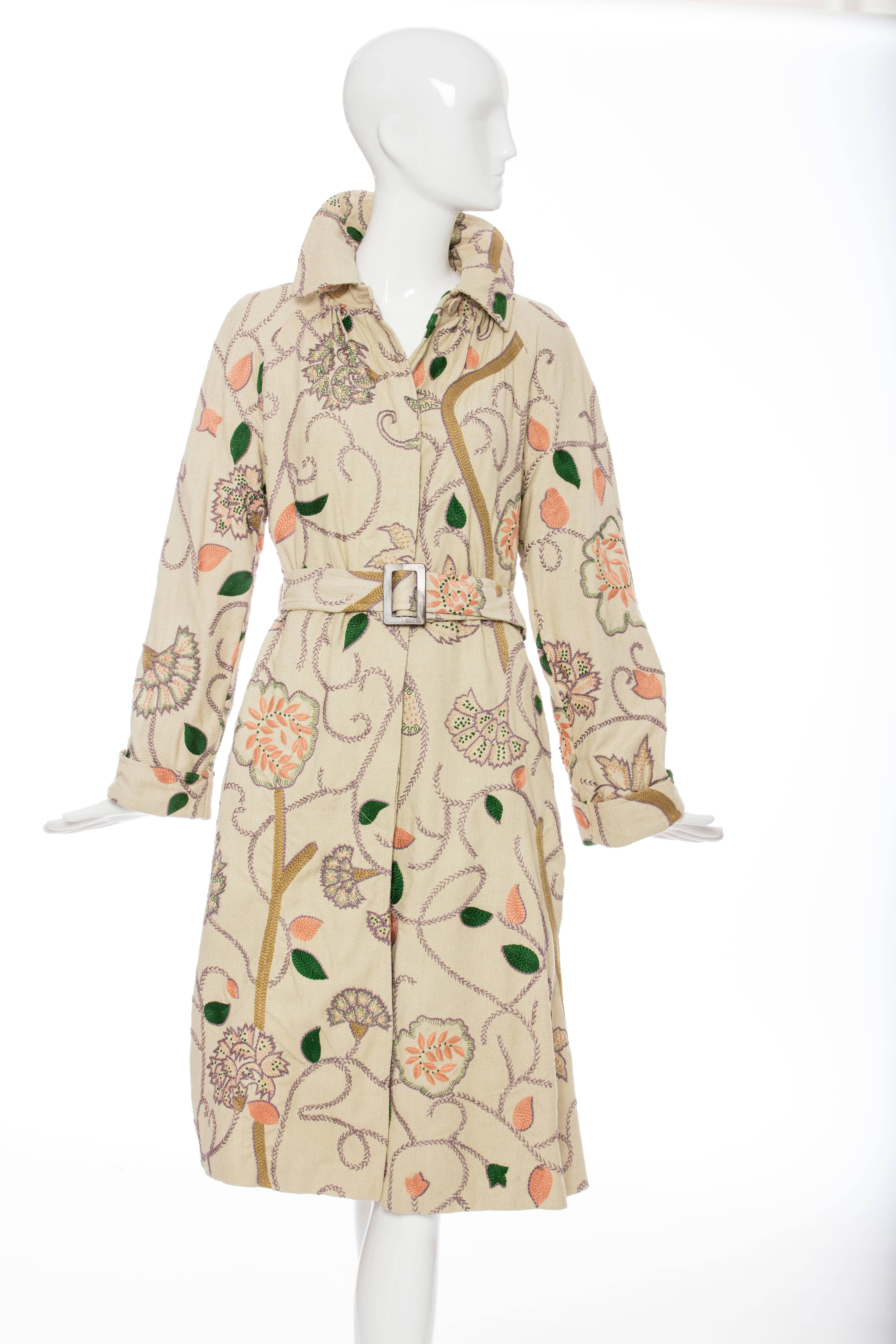 Dries Van Noten, Spring-Summer 2005 button front, cotton floral embroidered coat, dual seam pockets at sides, self belt and fully lined in silk.

Belgium: Small

Bust 36”, Waist 32”, Shoulder 15”, Length 41”, Sleeve 32”
Fabric Content: 100% Silk
