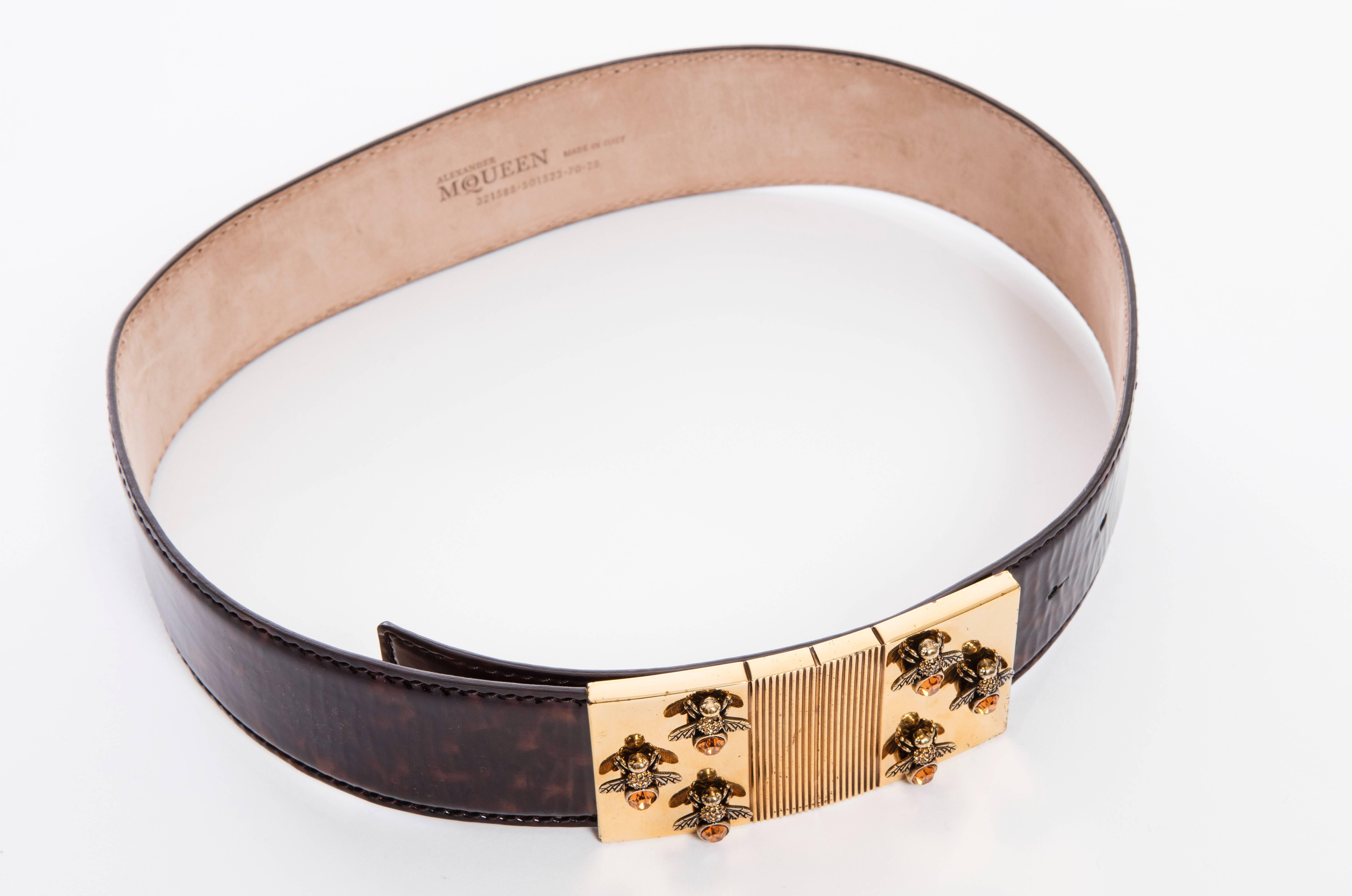 Alexander McQueen by Sarah Burton, Spring 2013 patent leather tortoise belt with tonal stitching and gold-tone bee buckle featuring peg-in-hole closure. Includes dust bag

Length 26“-30.5”, Width 2”