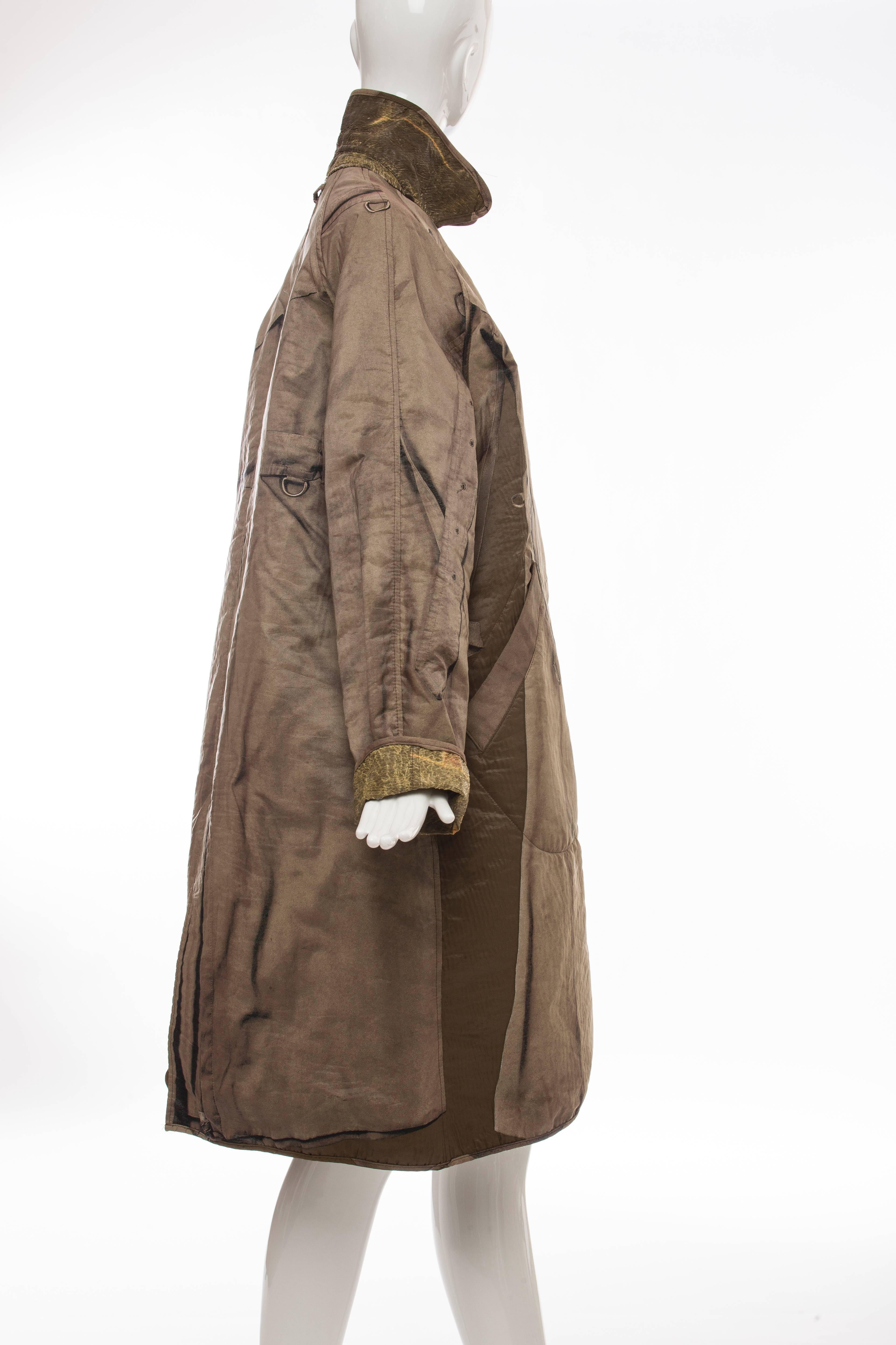 Jean Paul Gaultier, Autumn-Winter 2004, reversible tromp l'oeil trench coat with dual slit pockets at waist, Peter Pan collar, vent at back and button closures at front. 

Size not listed, estimated from measurements.

 Bust 46”, Waist 50”,