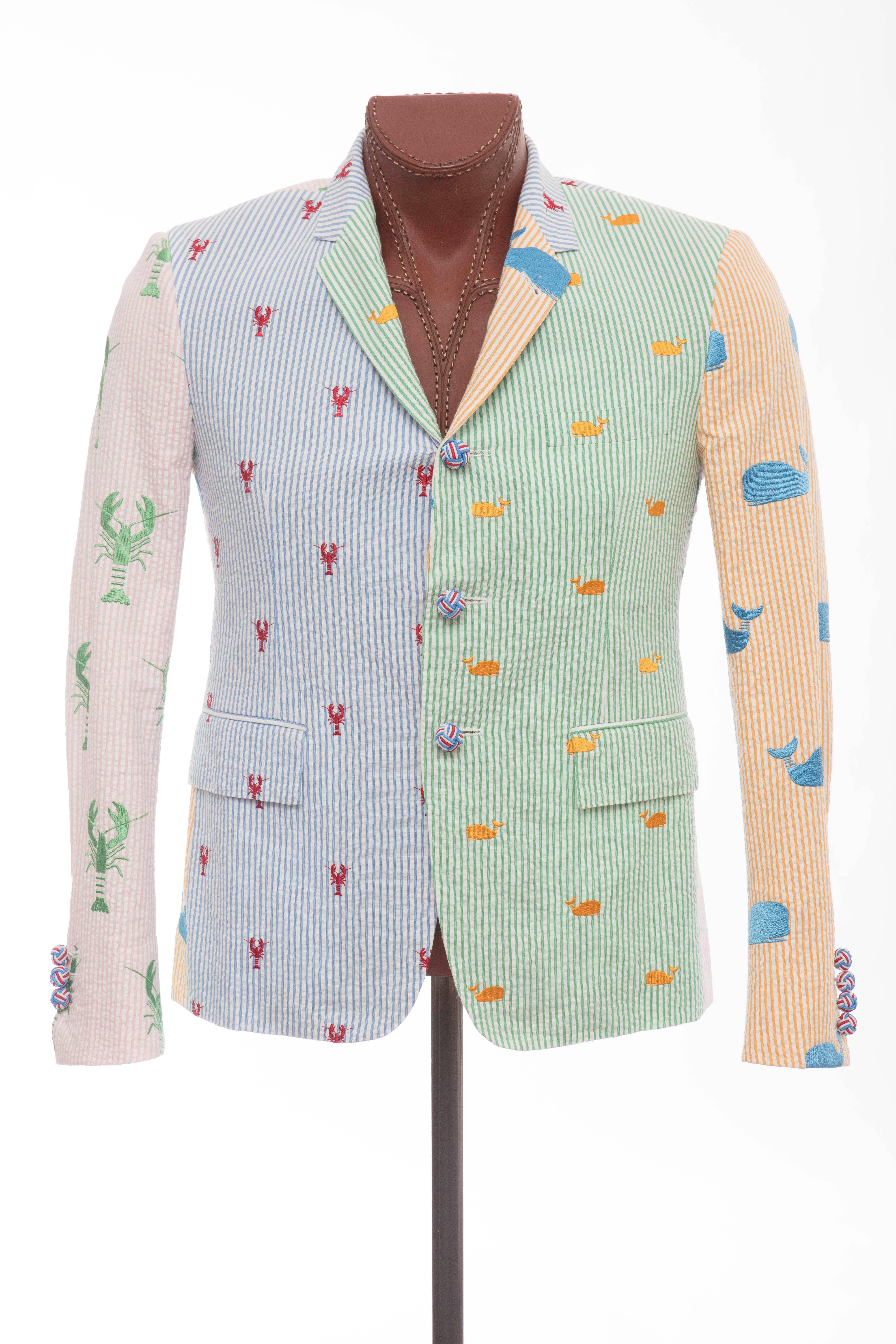 Thom Browne, Spring 2013 blue, green, tangerine and pink seersucker blazer with whale and lobster embroidery throughout, notched lapels, three front pockets, three interior welt pockets, two back hem vents and front button closures. 

Designer
