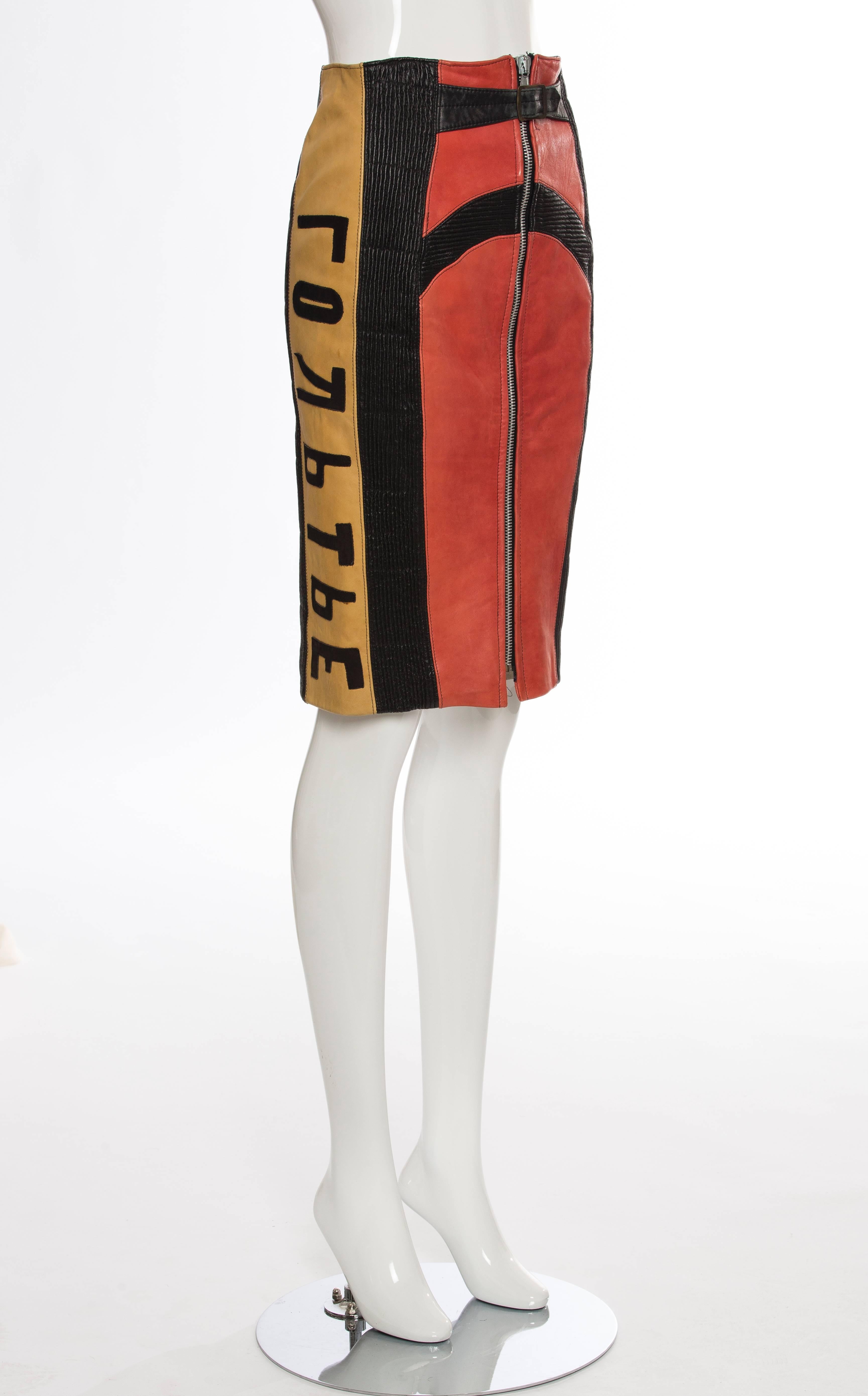 Jean Paul Gaultier, Autumn - Winter 1986 'Russian Constructivist' collection leather zip front skirt featuring smocked leather accents throughout, flocked cyrillic script panels at sides, belt accent at waist and fully lined.

IT. 42
US.