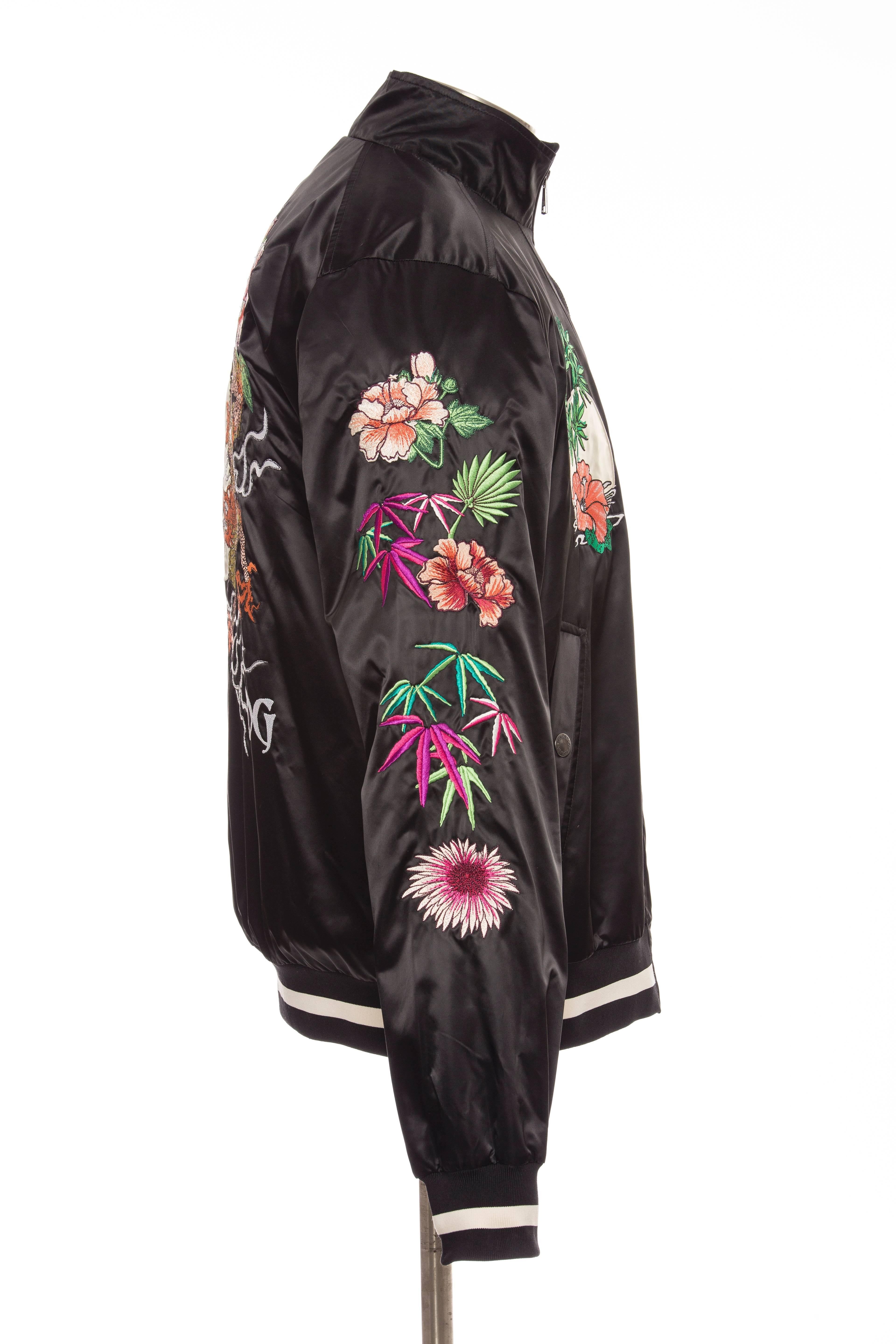 Dolce & Gabbana men's black satin embroidered souvenir jacket with floral and dragon embroidery throughout, striped rib knit trim, dual snap pockets and zip closure.

IT.  52
US. 42

Chest 44”, Shoulder 17”, Length 27”, Sleeve 36“
Fabric Content: