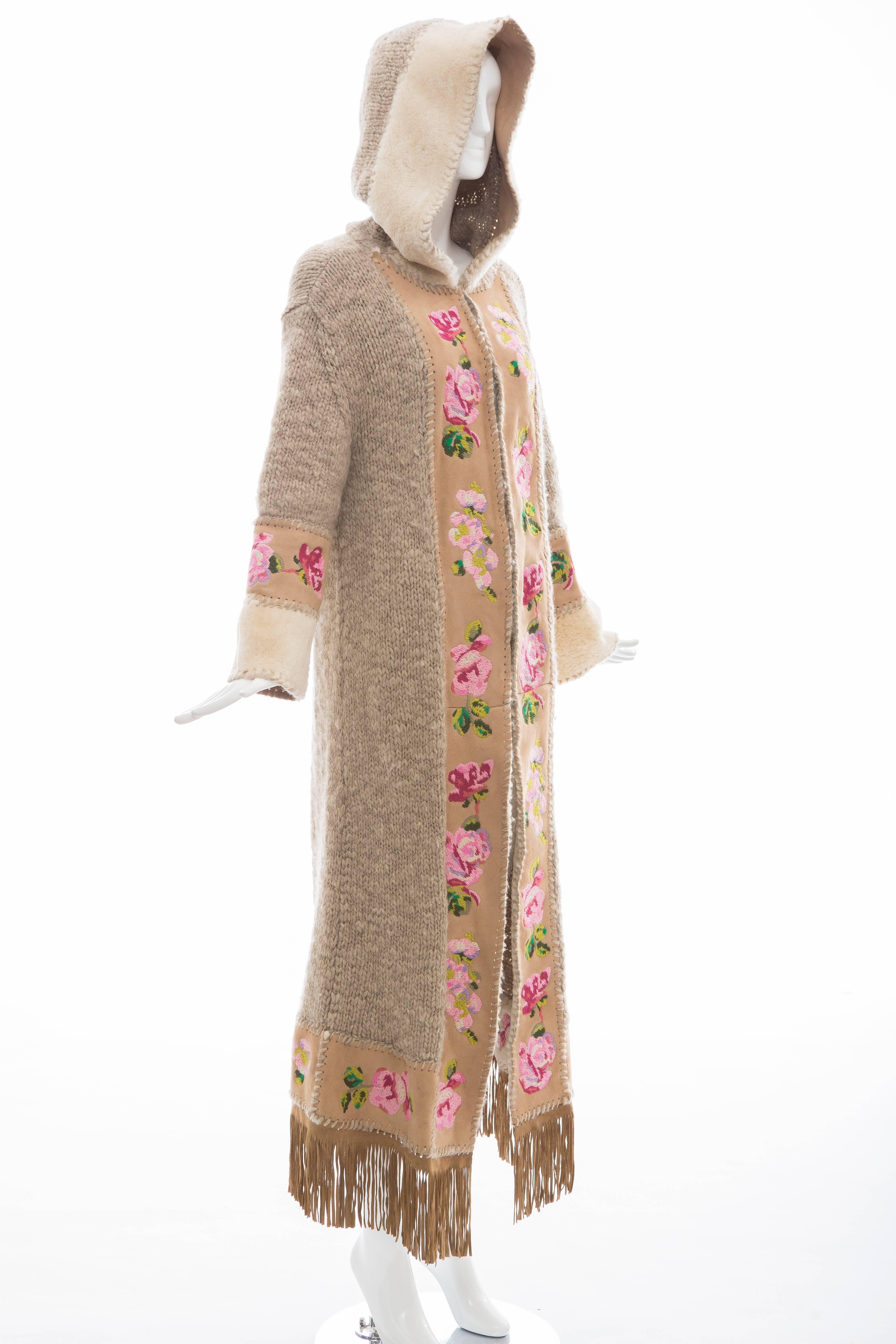 John Galliano for Christian Dior, wool duster with attached hood, suede fringe trim at hem, floral embroidered suede trim and shearling trim throughout and concealed hook closure at front.

90% Wool, 10% Nylon; 100% Leather
Measurements: Bust 40”,