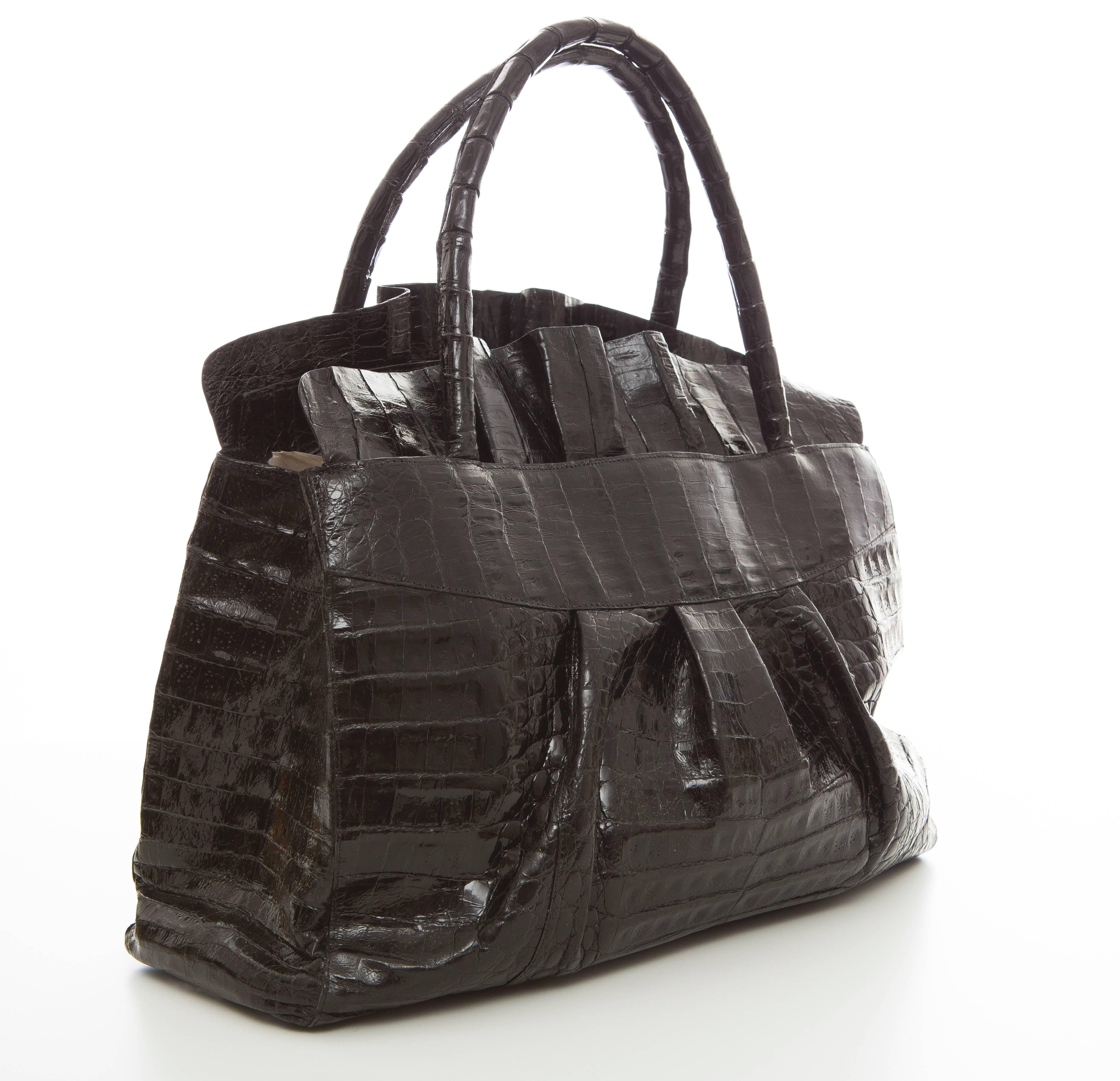 Nancy Gonzalez shiny black medium crocodile ruffle tote,dual rolled handles, two interior zip pockets, three interior pouch pockets, burgundy suede interior, magnetic flip top closure, five alligator covered feet for protection and optional shoulder