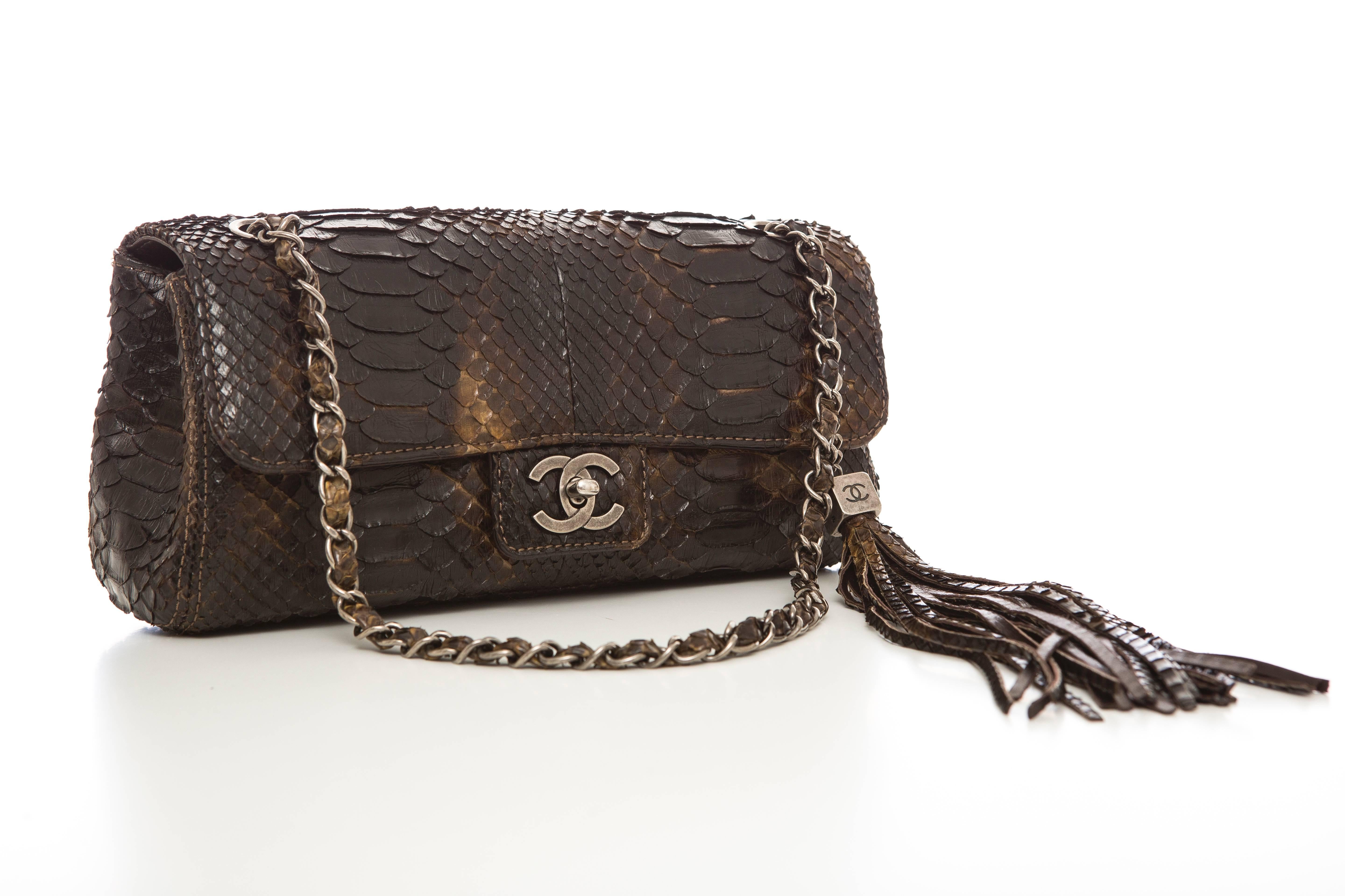Chanel Soho tassel single flap python medium bag with antiqued silver-tone hardware, curb-chain shoulder strap, tassel charm at side, brown leather interior, two interior wall pockets and CC turn-lock closure at front flap. Comes with dust bag and