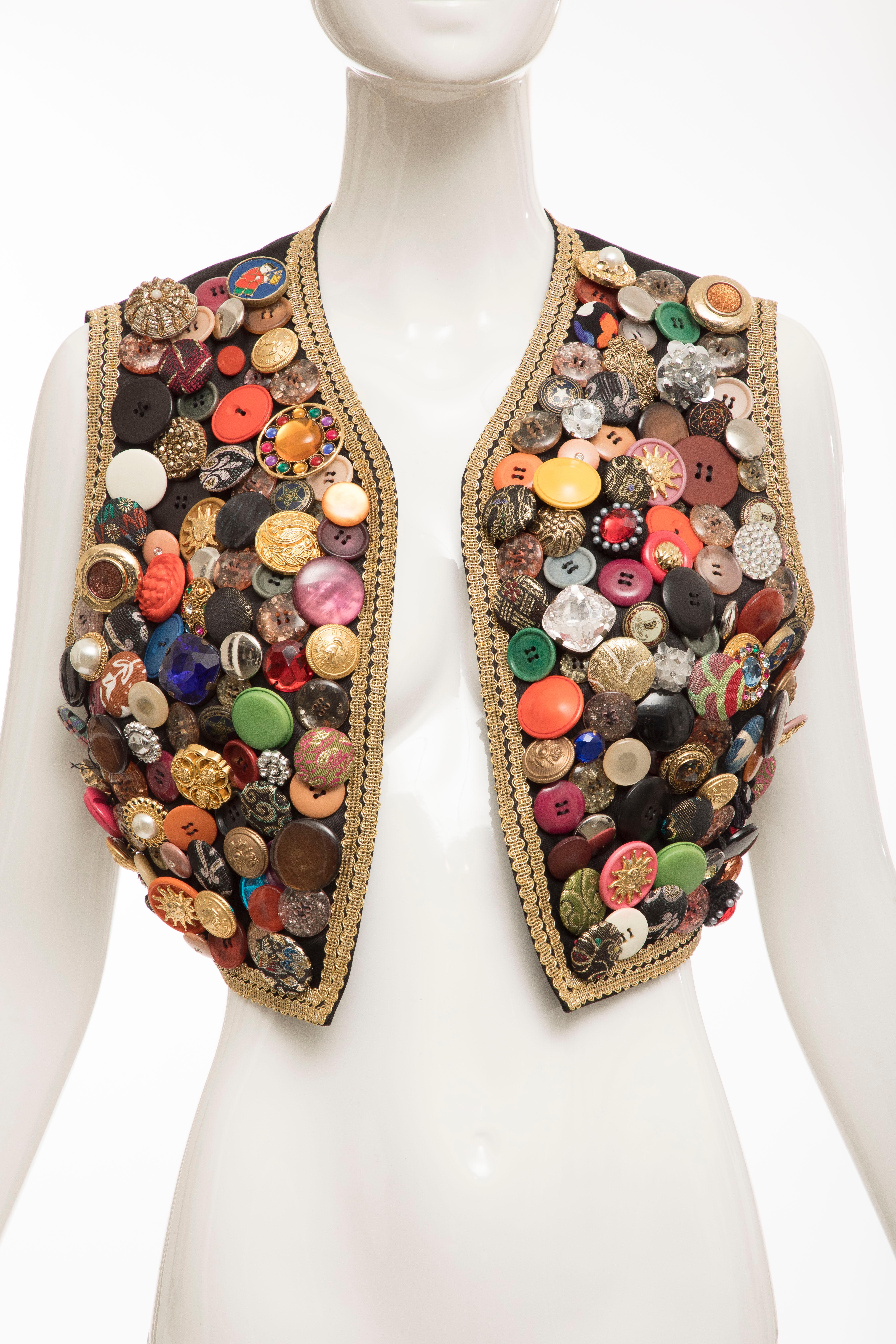 Dolce & Gabbana, Circa: 1990's black multi button cotton vest with gold ribbon trim.

IT: 44
US: 8
Bust: 34, Shoulder: 14, Length: 16