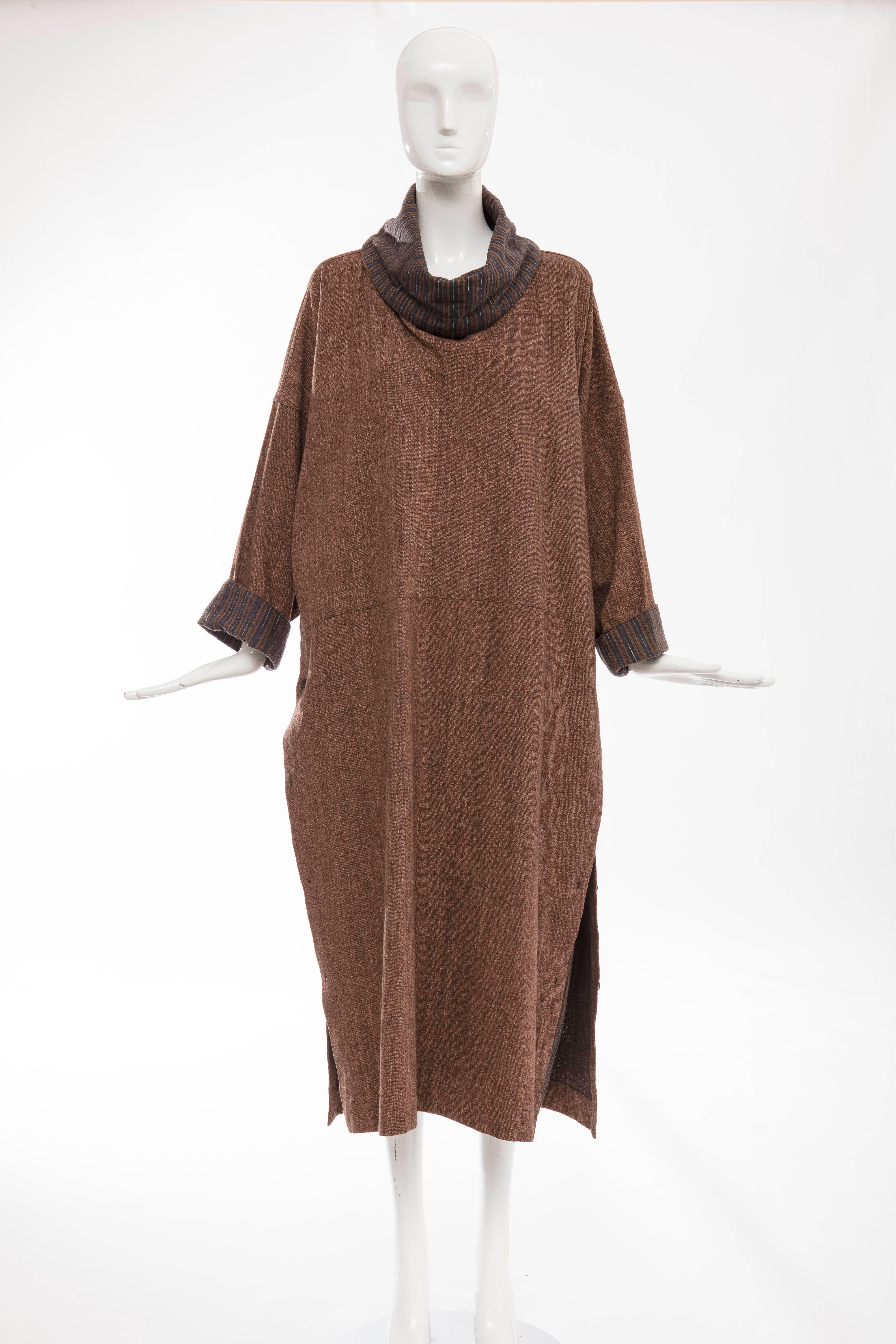 Issey Miyake Plantation, circa 1980's  woven cotton double layered dress with brown blue striped cowl neck and cuffs, two front pockets and double side wooden button closure.

Japan: Medium

Bust 56", Waist 46", Hips 52" Length