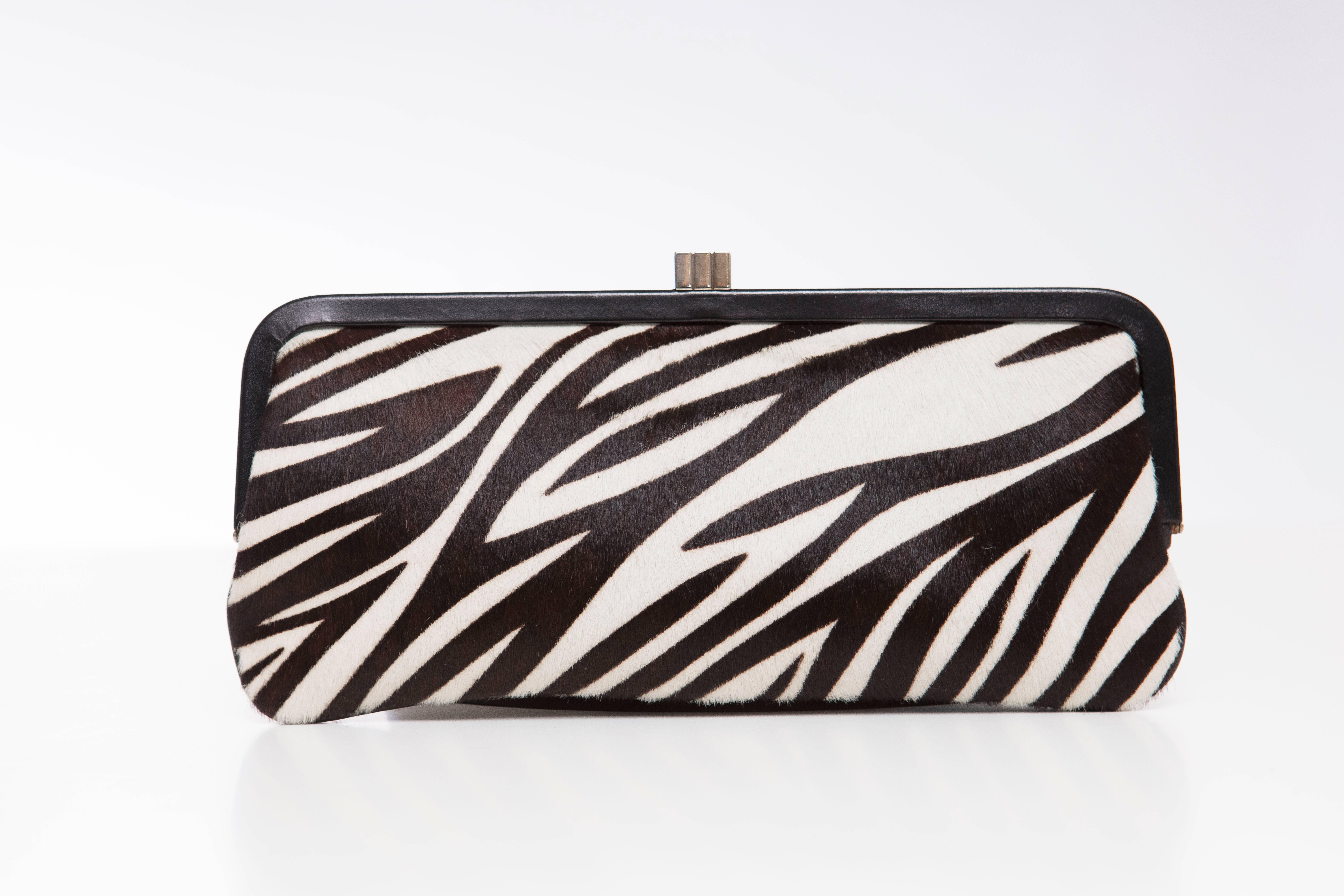 Lambertson Truex black and white zebra print pony hair clutch with silver-tone hardware, black leather trim, blue leather interior, single pocket at interior wall with zip closure and push-lock closure at top.

Height: 4.5, Width 10, Depth 0.25



