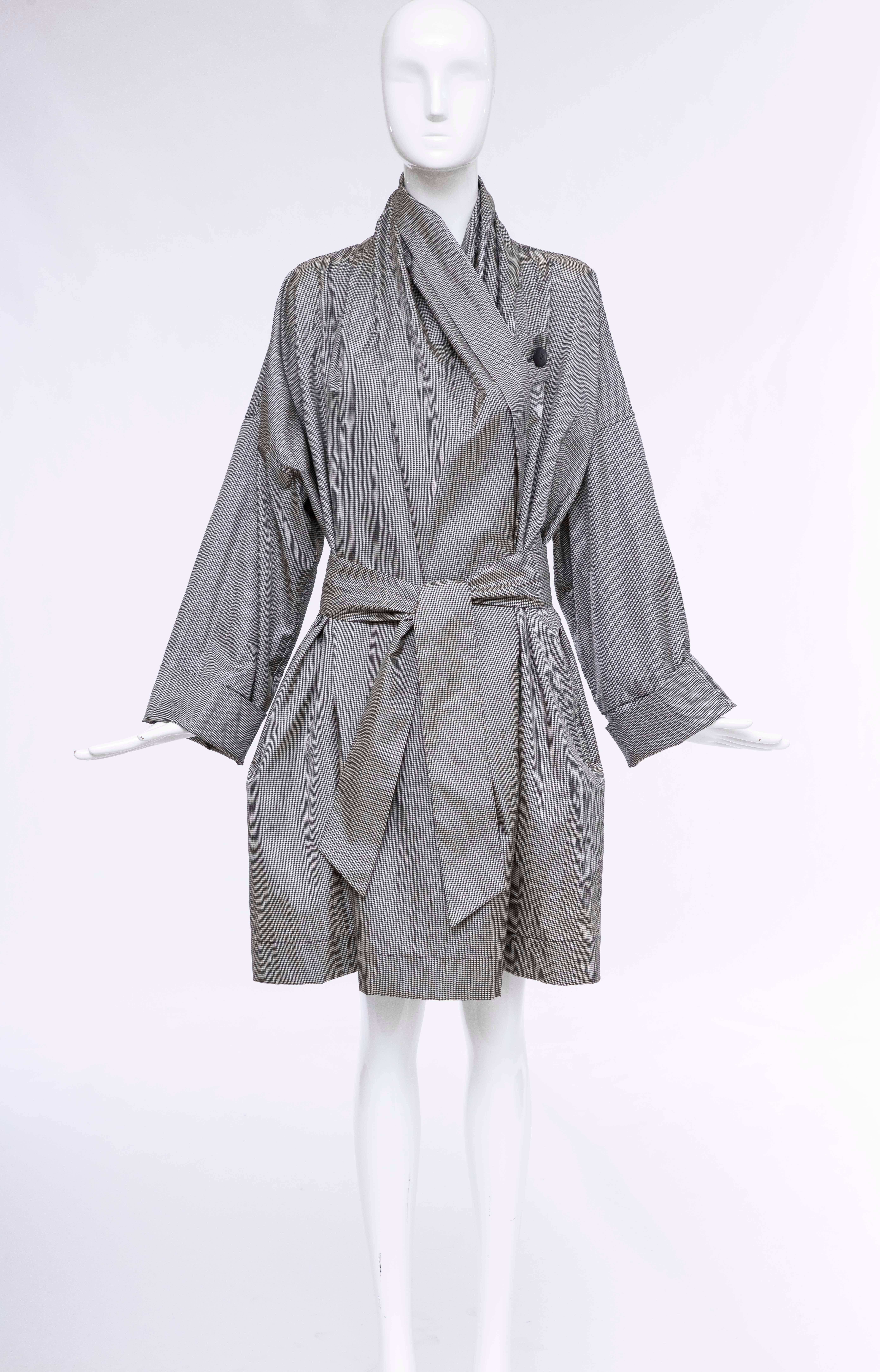  Issey Miyake, Circa: 1985 layered houndstooth nylon trench coat with asymmetrical draping throughout, tonal insert at interior bodice, shawl lapels, dual welt pockets at sides, gathered nape, tonal sash tie at waist and contrasting button closures