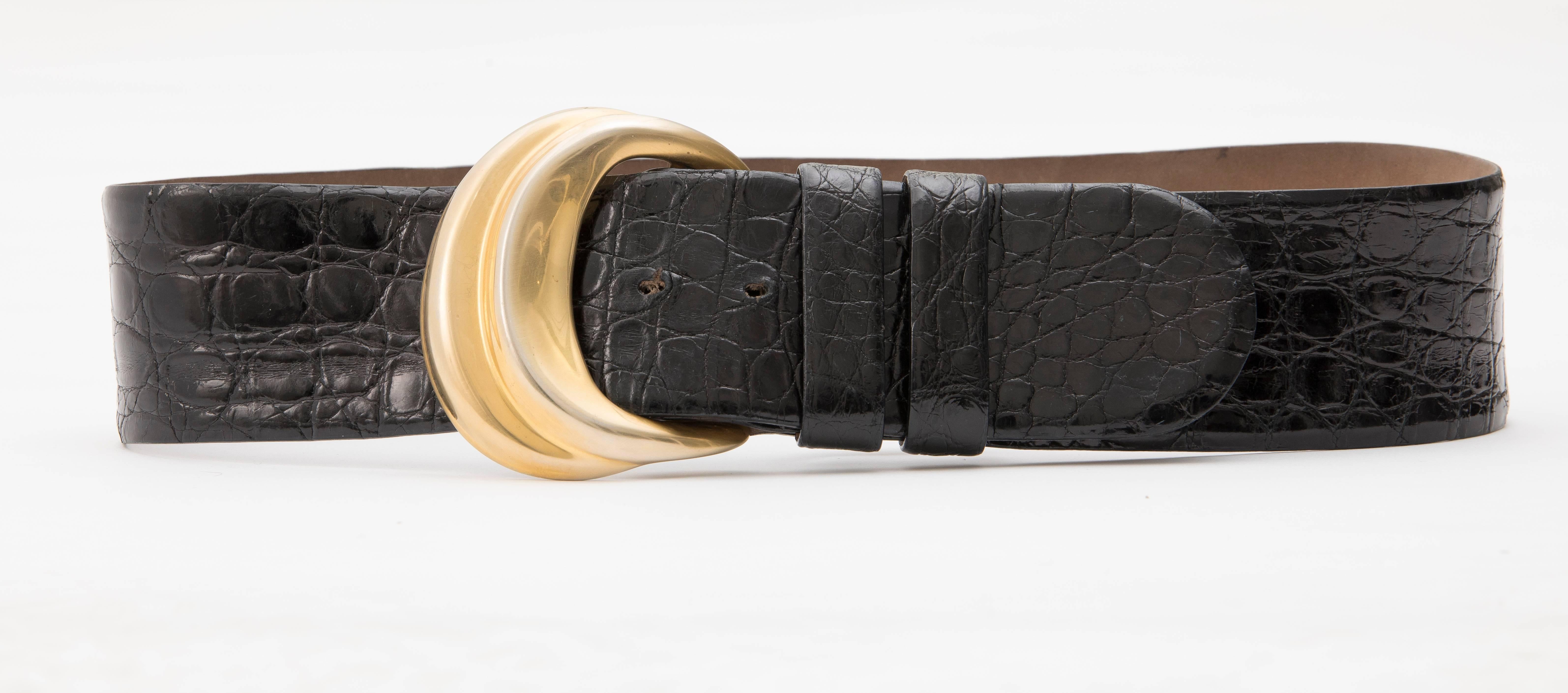 Donna Karan, Circa 1980's black Caiman Crocodile waist belt with tonal stitching and Robert Lee Morris gold-tone buckle with peg-in-hole closure.

Size: Large

Length Min: 32, Length Max: 35, Width: 2.5
