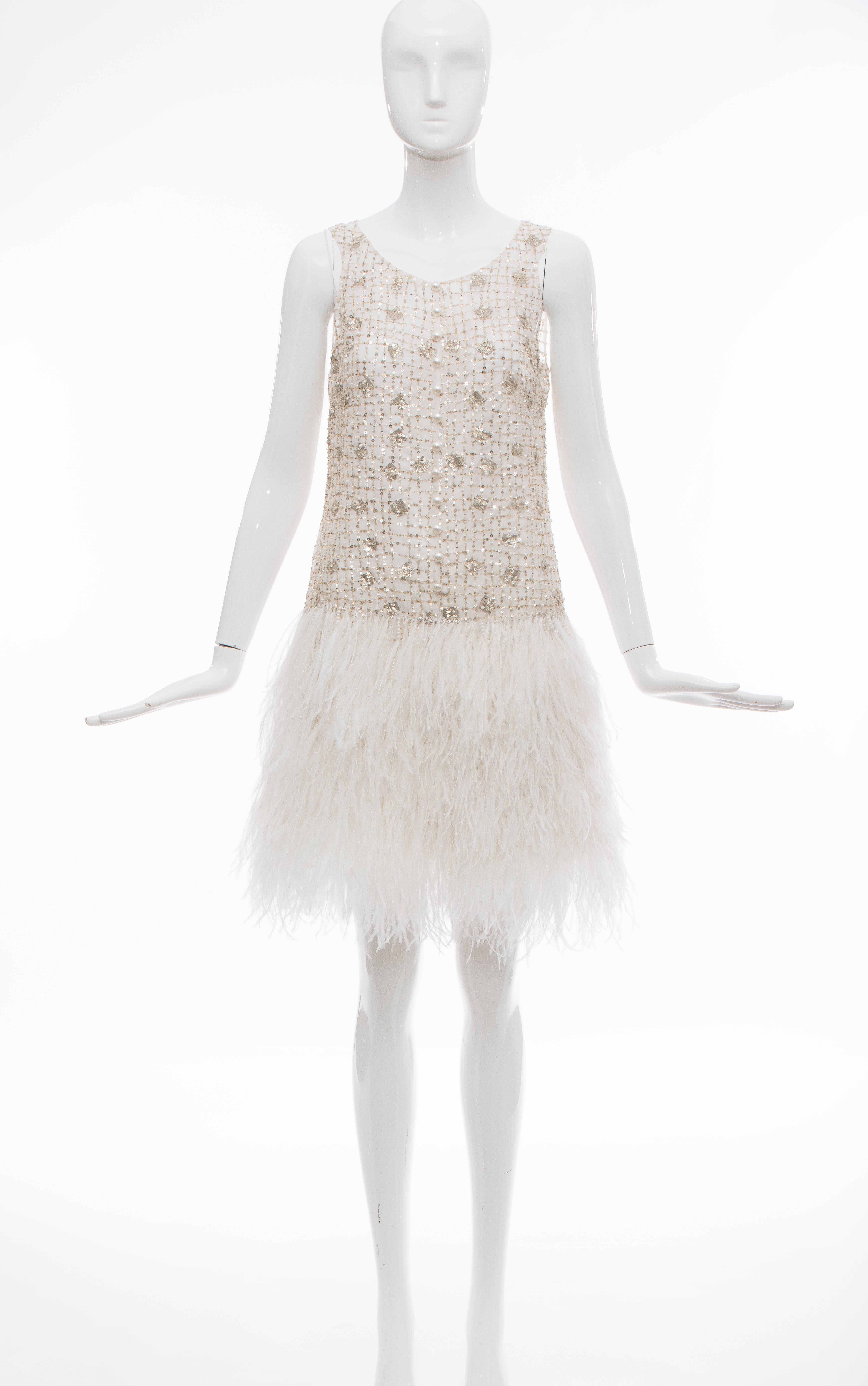 Oscar de la Renta sleeveless evening dress with metallic sequin and pearlescent beaded accents throughout, ostrich feathers at dropped waist skirt, pearlescent button details at center front and key hole at center back featuring button closure.

US.