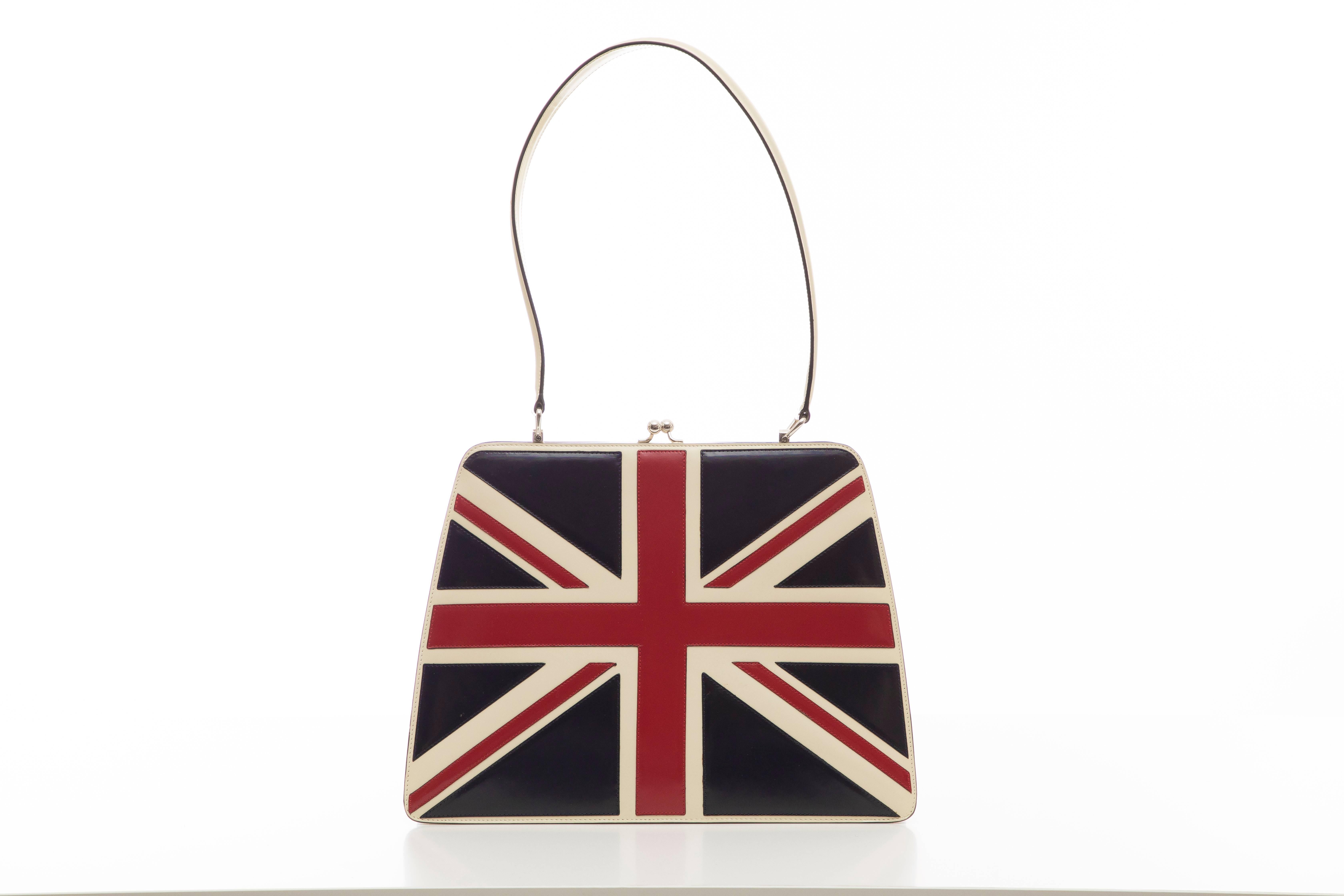 Moschino vintage bag with silver-tone hardware, single flat shoulder strap, Union Jack motif at front, beige jacquard lining, single interior zip pocket and kiss-lock closure at top. 

Shoulder Strap Drop: 10, Height 9.5, Width 12.5, Depth 2
