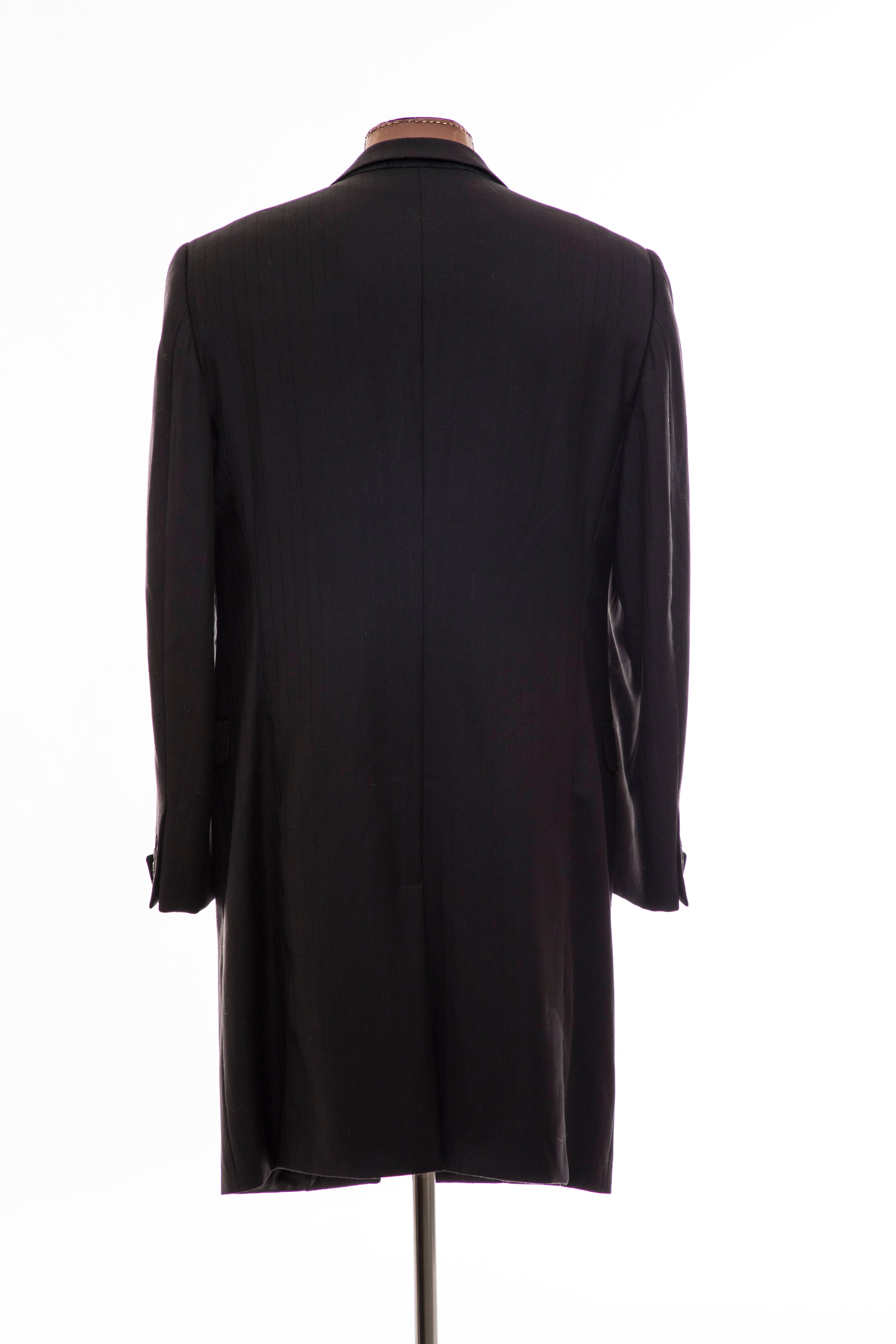 Gianni Versace Couture, circa 1990's black pinstriped wool men's overcoat with peak labels, cuffed sleeves, single hidden button closure, three interior pockets, back vent and fully lined. 

Chest 45, Waist 41, Hips 46, Shoulder 19, Sleeve 27.5,