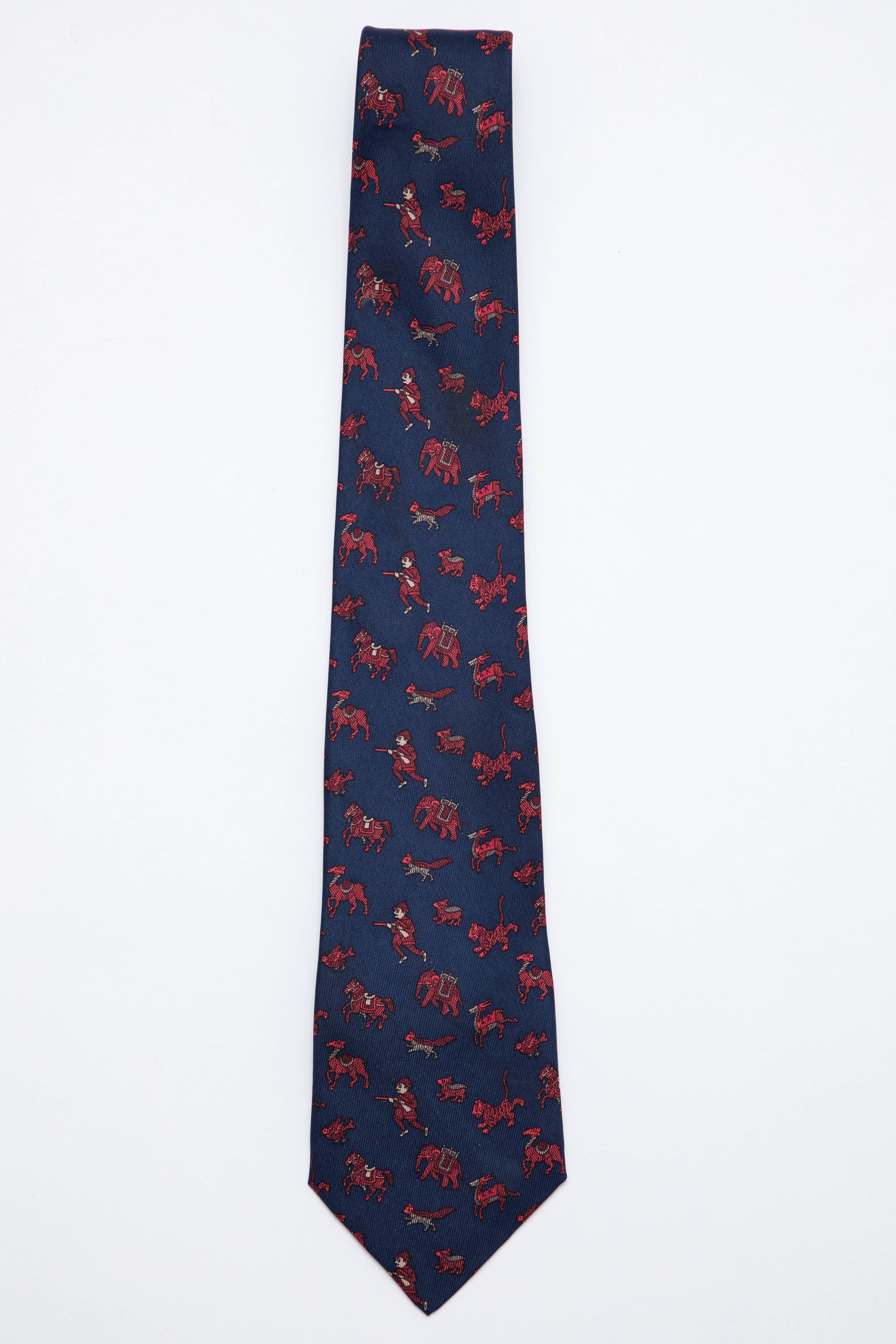  Hermès, Circa 1990's men's navy blue silk twill tie with red hunting motif throughout.

Length: 57