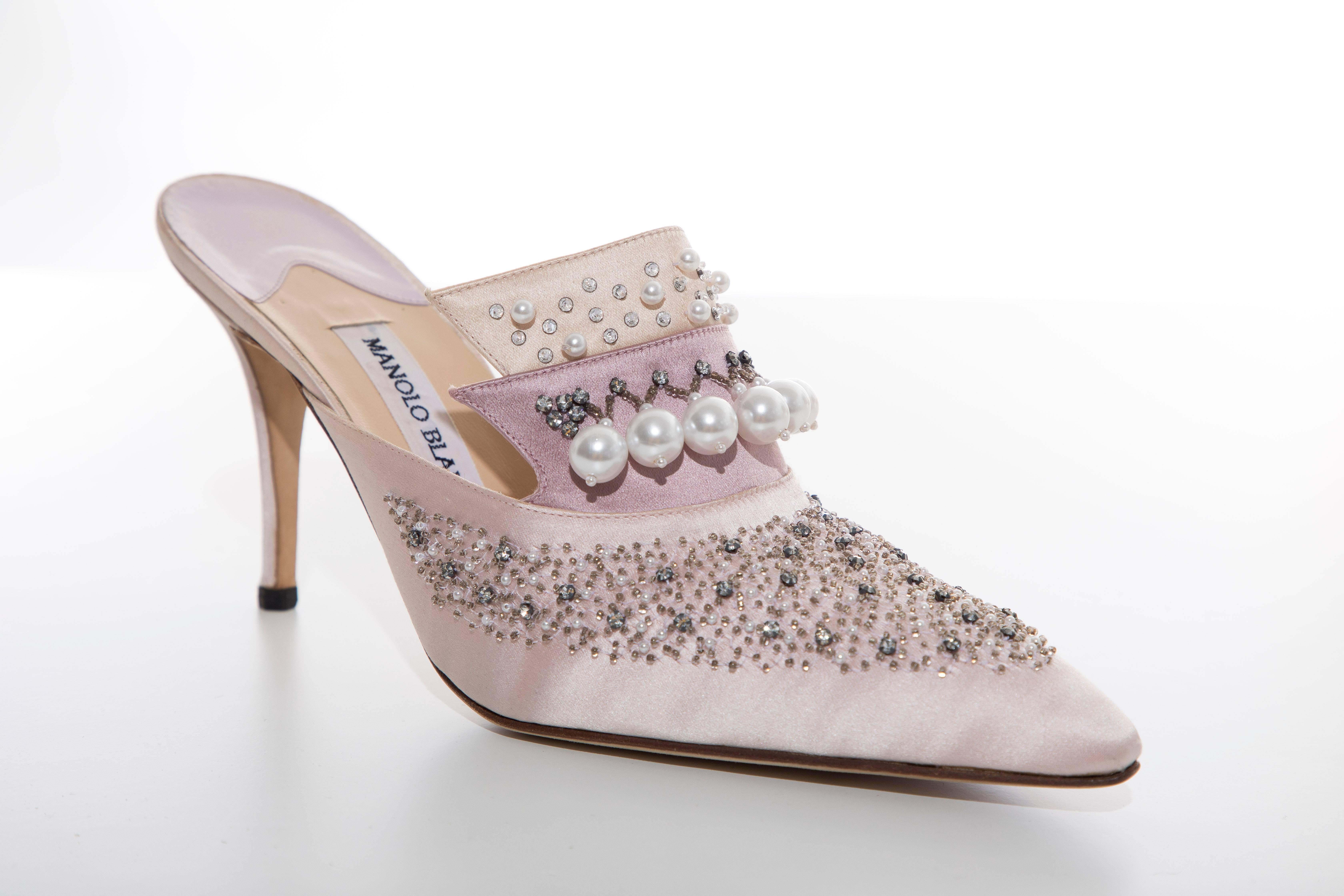 Manolo Blahnik, Circa: 1994  pink silk satin mules with pointed toes, faux pearl embellishments throughout and covered heels. Includes box.

EU. 39.5, US. 9.5

Heels: 3.5