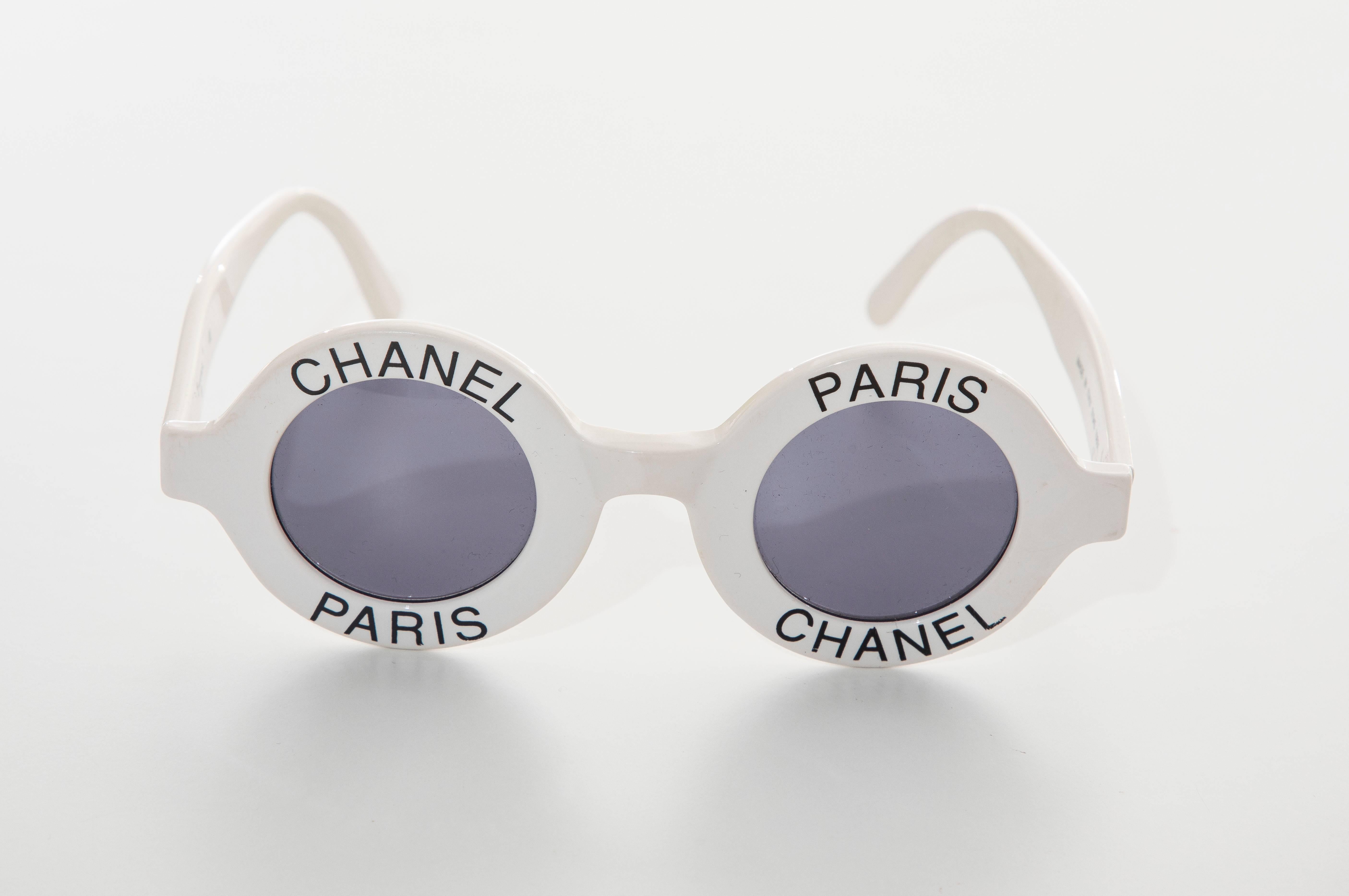  Chanel, Spring-Summer 1993 runway, logo, round white sunglasses with tinted lenses, black Chanel Paris accents at frames and interlocking CC detailing at temples. Includes case. 

 (page 162, CHANEL CATWALK, Patrick Mauries, Thames &