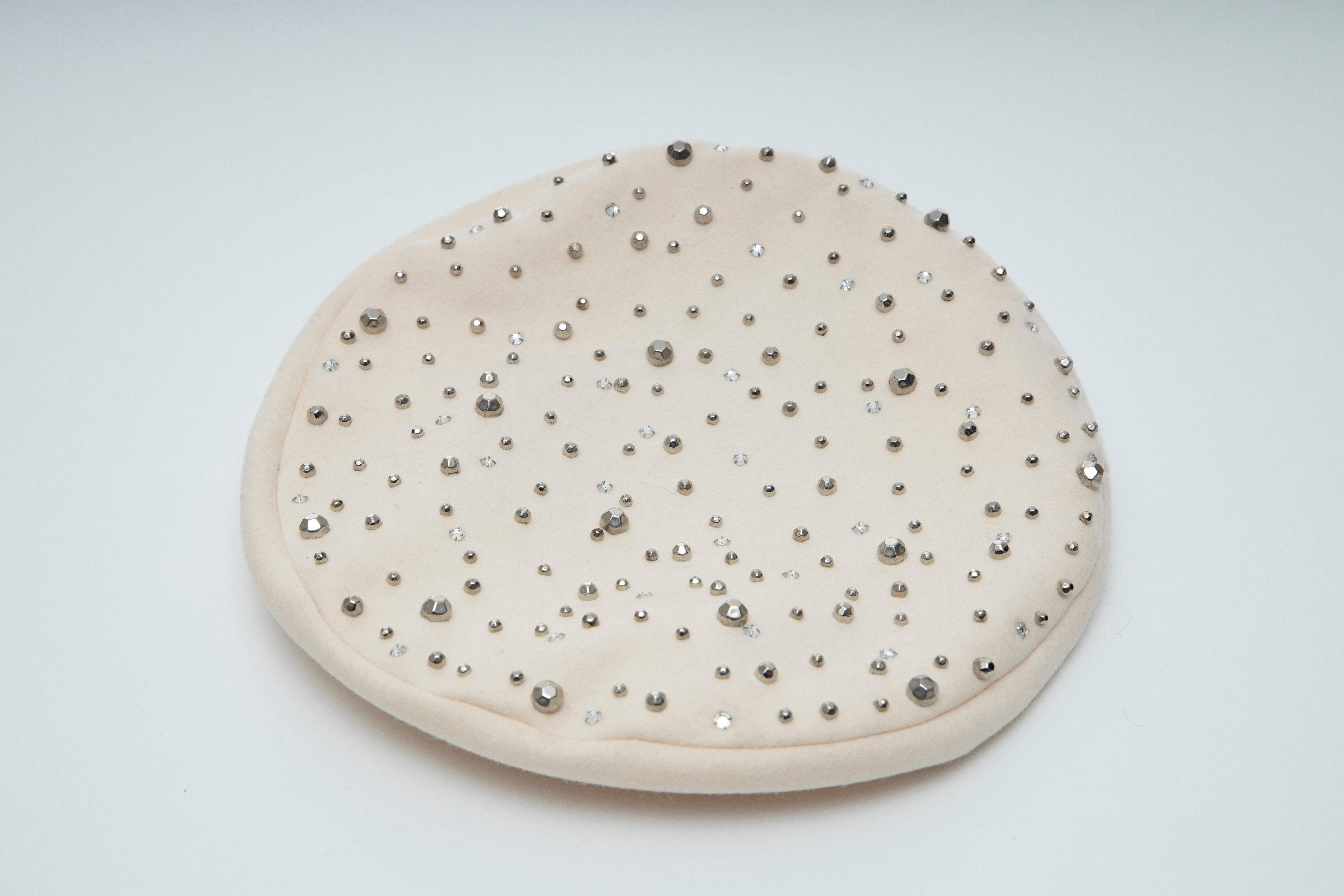 Adolfo, Circa:1960's Winter White Wool Faceted Silver Studs Prong Set Crystals Beret.

Circumference: 40 inches