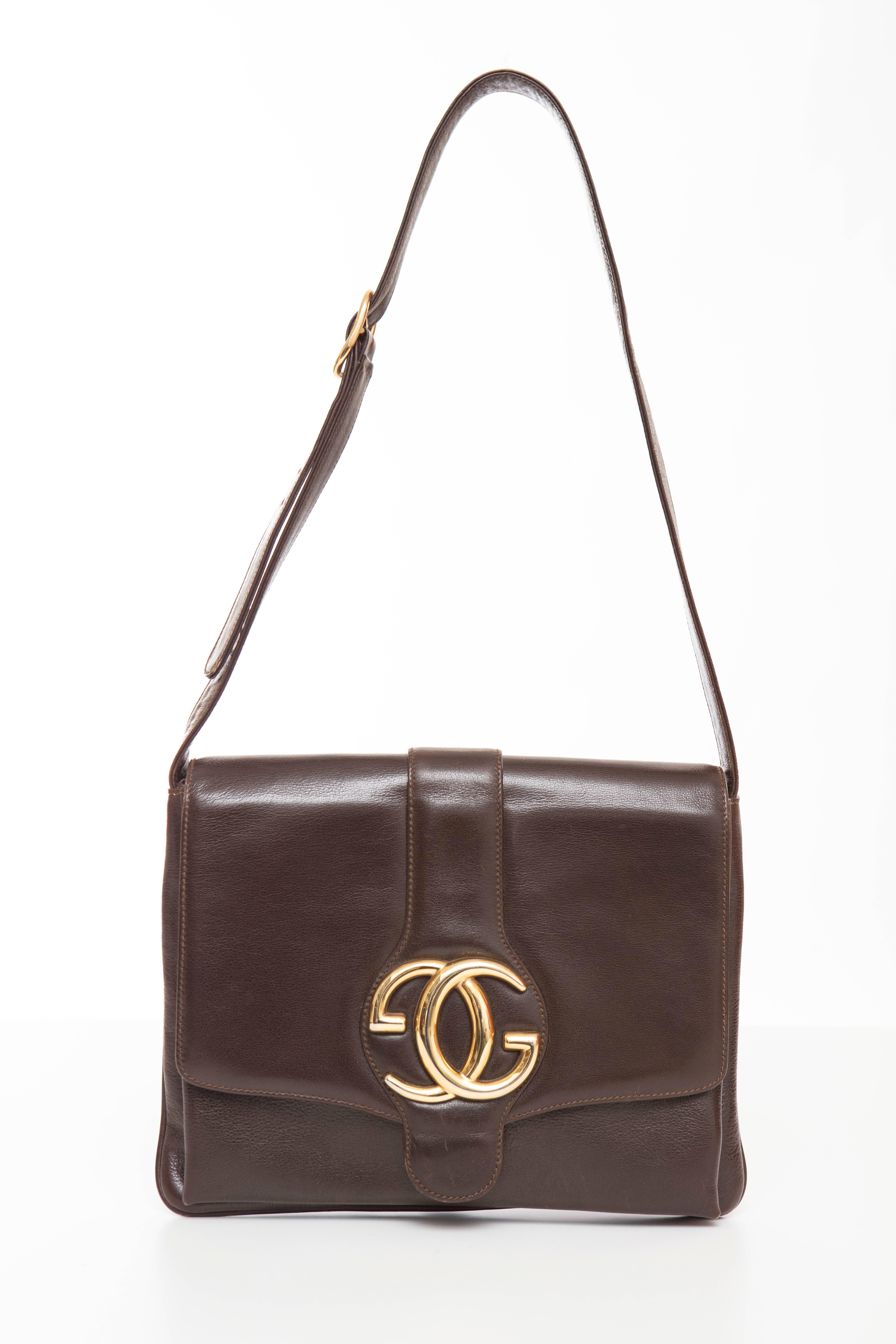 Gucci 1970's brown leather handbag with fold over top flap, gucci gold logo hardware, adjustable strap and two interior compartments with one zip deep pocket.

Serial Number: MOD.BREV 53289

Height 8, Width 10, Depth 1, Shoulder Strap Adjust To 13 -