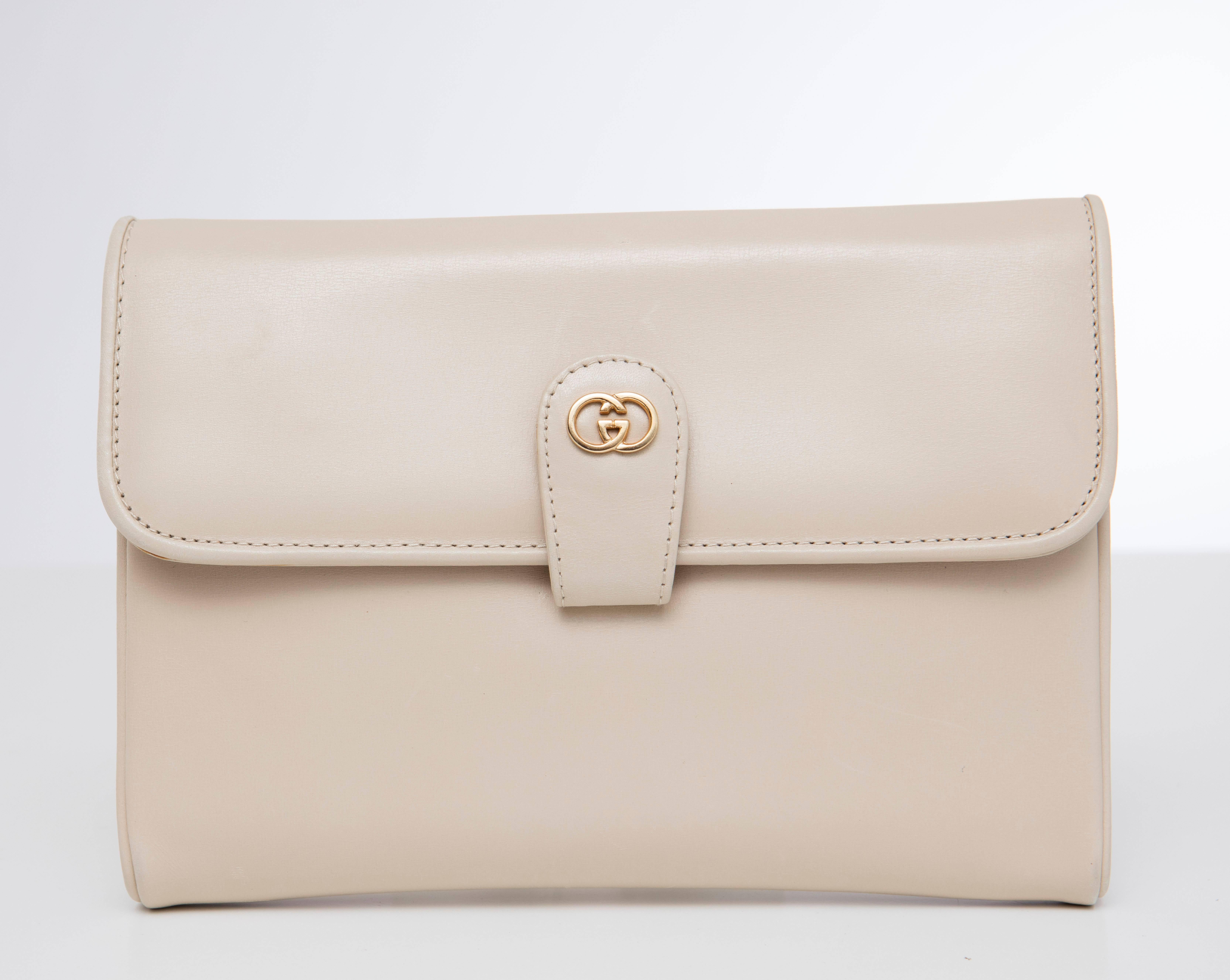 Gucci, circa 1970's cream leather snap front clutch with detachable strap, two interior compartments, one with  zipper pull and mirror. 

Width 8.5, Height 6
