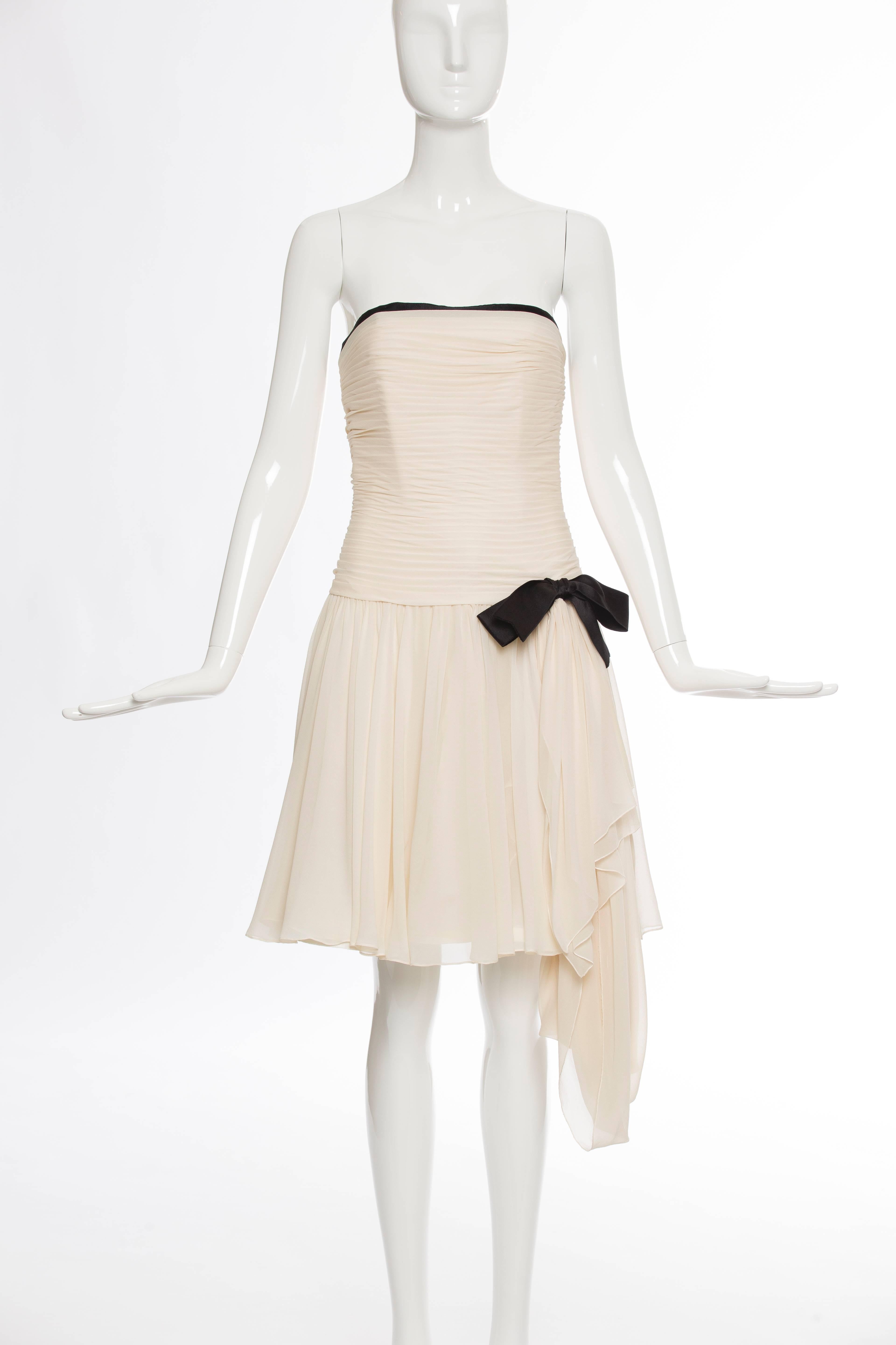 Chanel, circa 1980s, silk chiffon strapless dress with fitted ruched bodice, pleats at skirt featuring black satin draped bow, back zip and gold-tone button closure.

French size 36, US. size 4
Bust 28