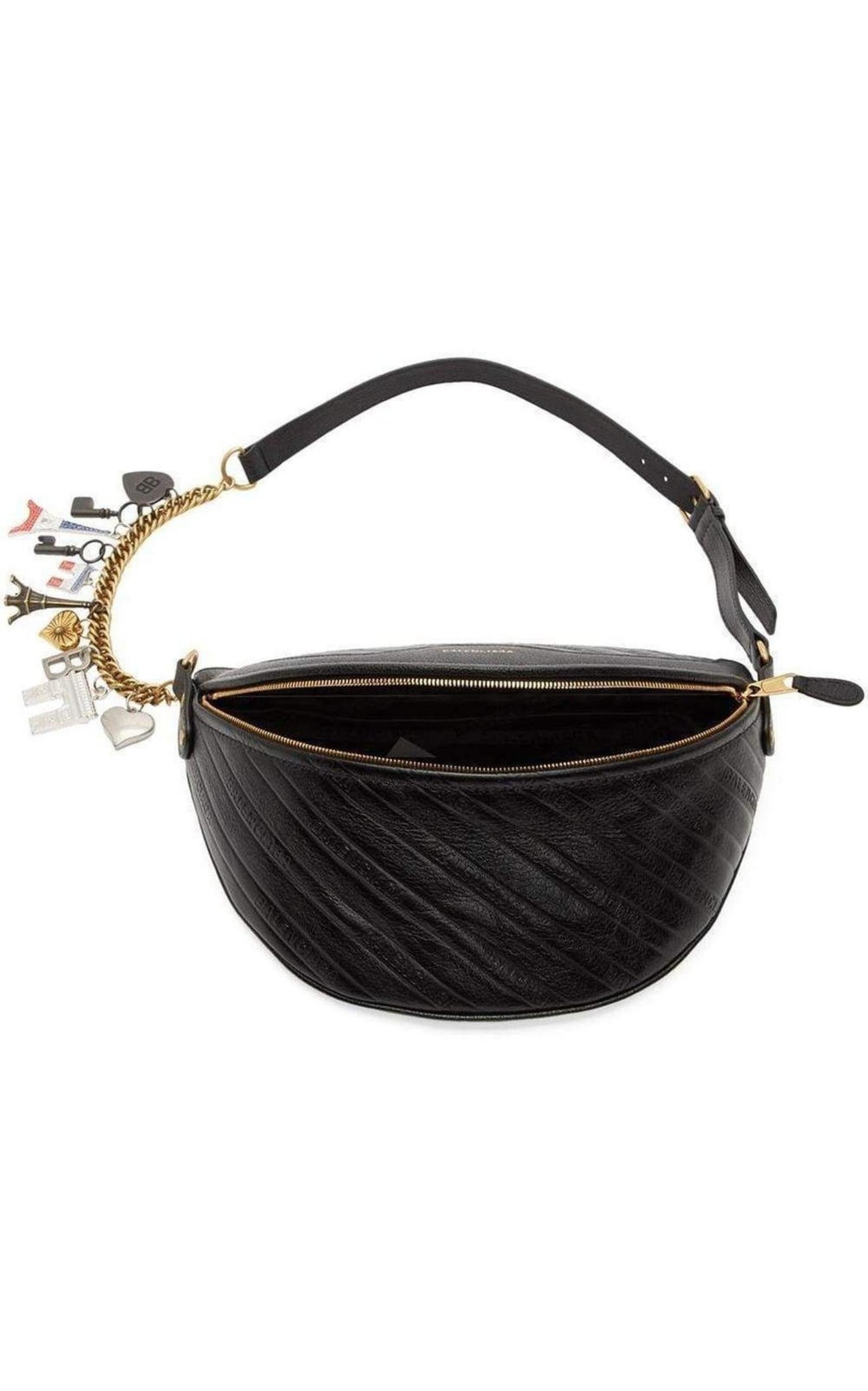 Sac en cuir de chèvre grainé de couleur noire, avec logo embossé sur l'ensemble du sac.
Ceinture réglable en cuir et en chaîne, ornée de charmes sculptés et fermée par une boucle à ardillon.
Estampille du logo en ton or sur la face avant.
Poche