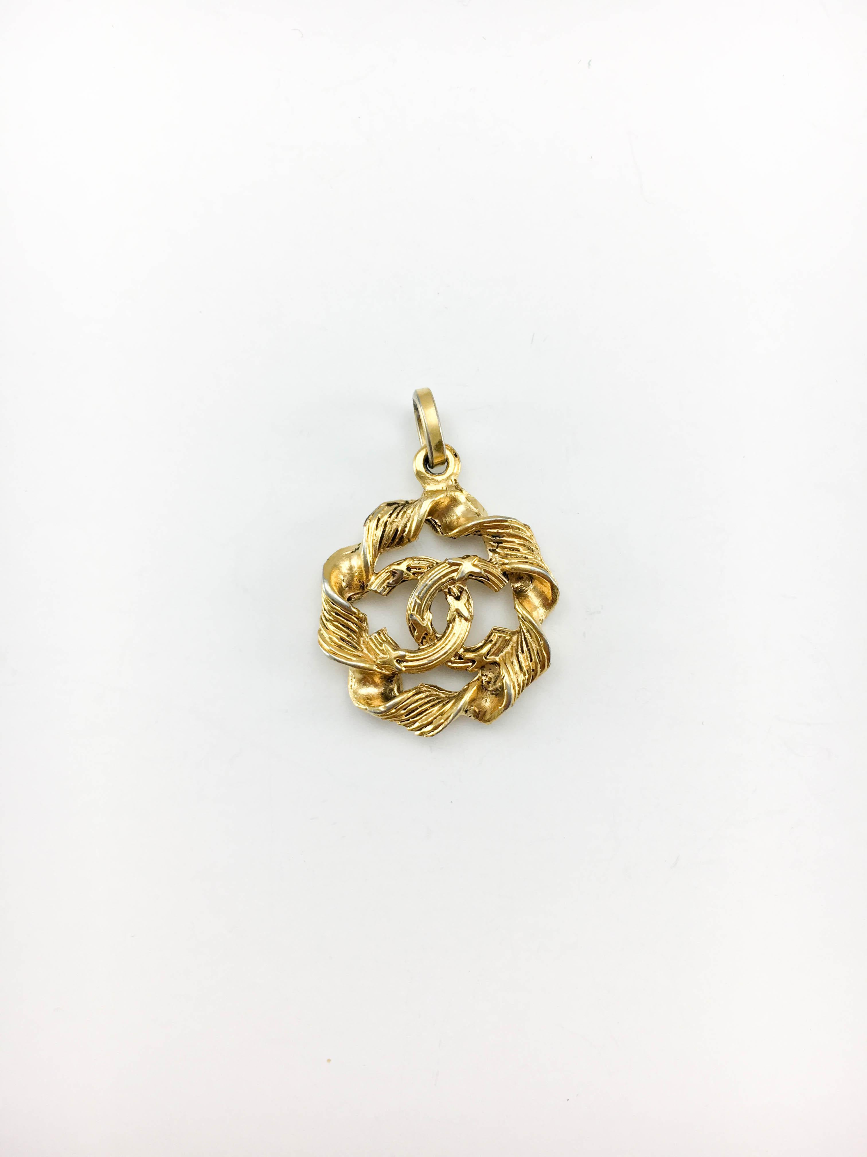Vintage Chanel Gilt Logo Pendant. This pretty Chanel pendant dates back from the 1970’s. Crafted in gilt base metal, the design features a twisted rim with the iconic ‘CC’ logo in the middle. In very good condition, it show some slight rubbing on