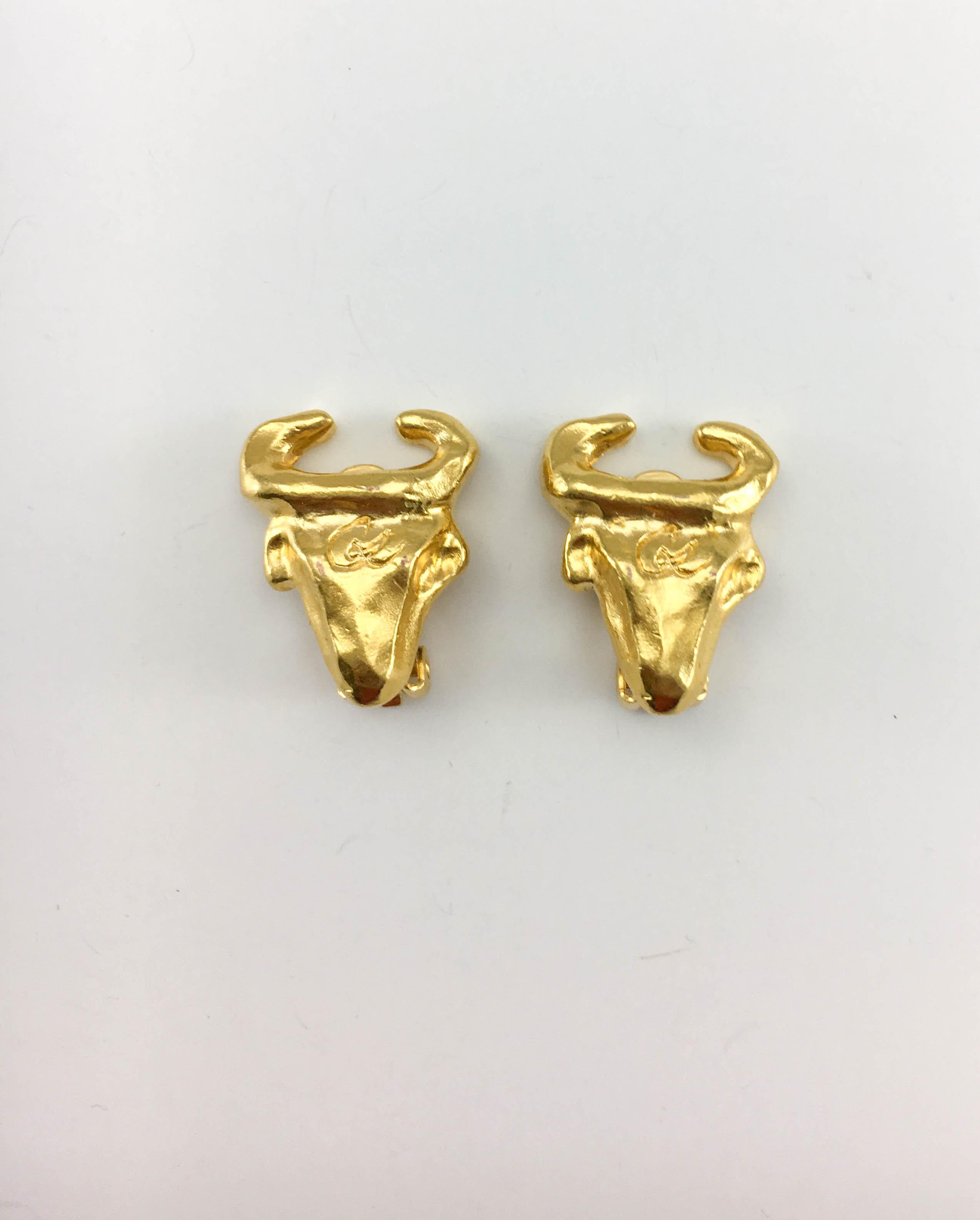 Vintage Christian Lacroix Gold-Plated Bull Head Clip-On Earrings. These striking earrings by Lacroix date back from the 1990’s. Crafted in gold-plated metal, they feature a stylised bull head with the Christian Lacroix logo engraved on the forehead.