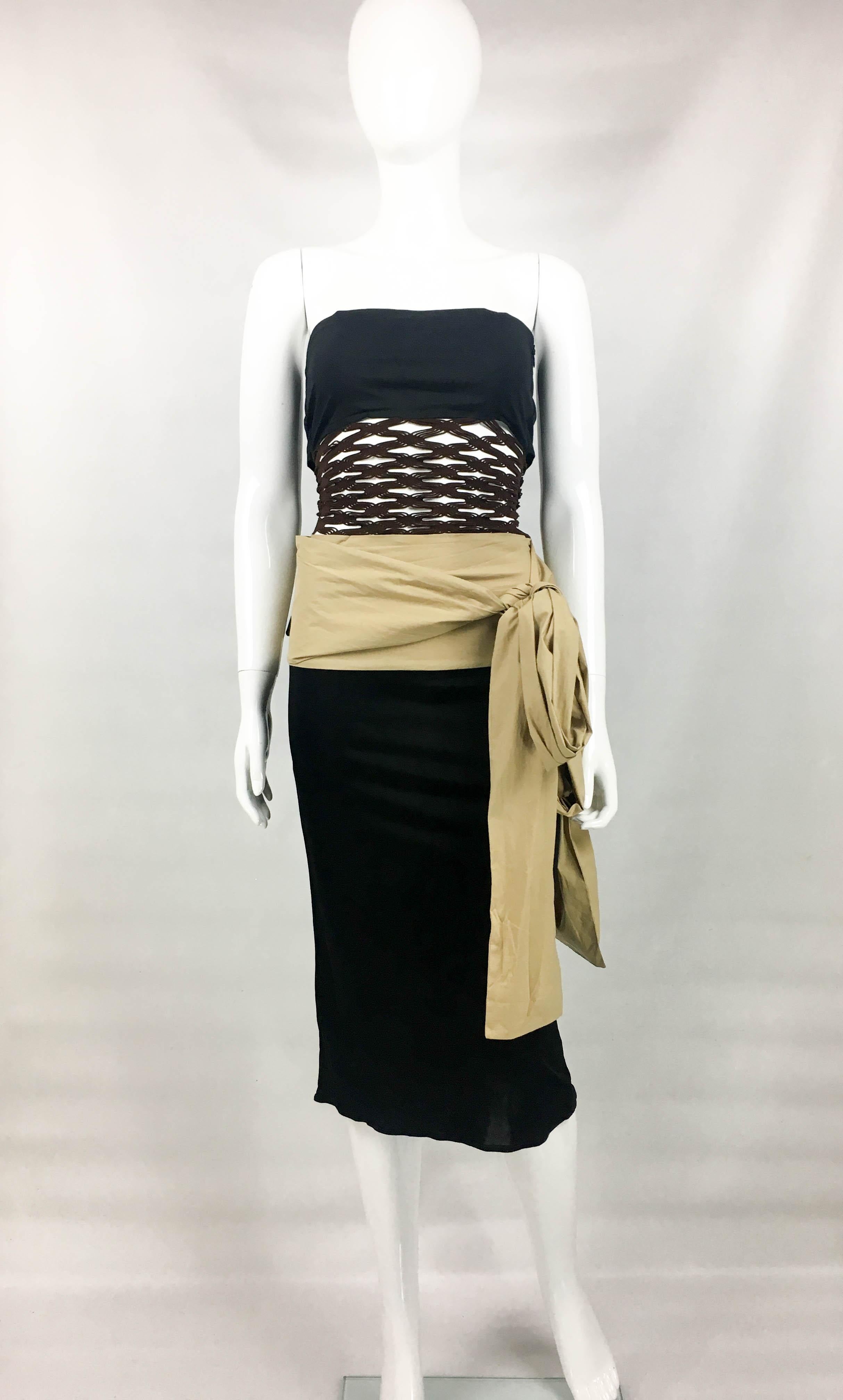 Vintage Jean Paul Gaultier Dress. This striking dress by Jean Paul Gaultier dates back from the 1990’s. Of interesting design, it features black and beige body and brown elastic net panel to torso. The beige and black sash-style details to the hip