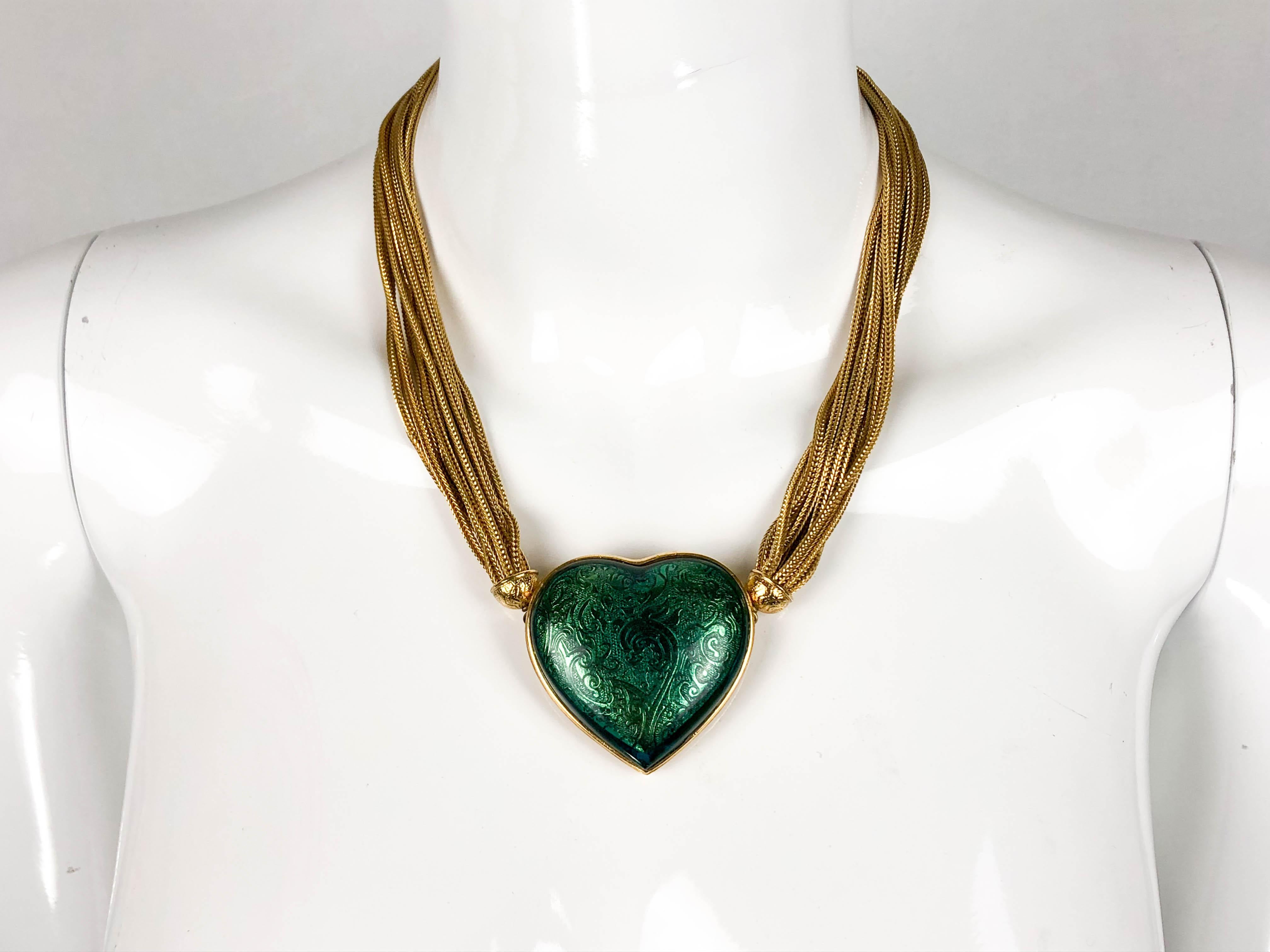 Vintage Yves Saint Laurent Gilt Chain Green Heart Pendant Necklace. This gorgeous piece by Yves Saint Laurent dates back from the 1980’s. Multiple chains are put together as tassels with no open end. Right in the middle, there is an emerald-green