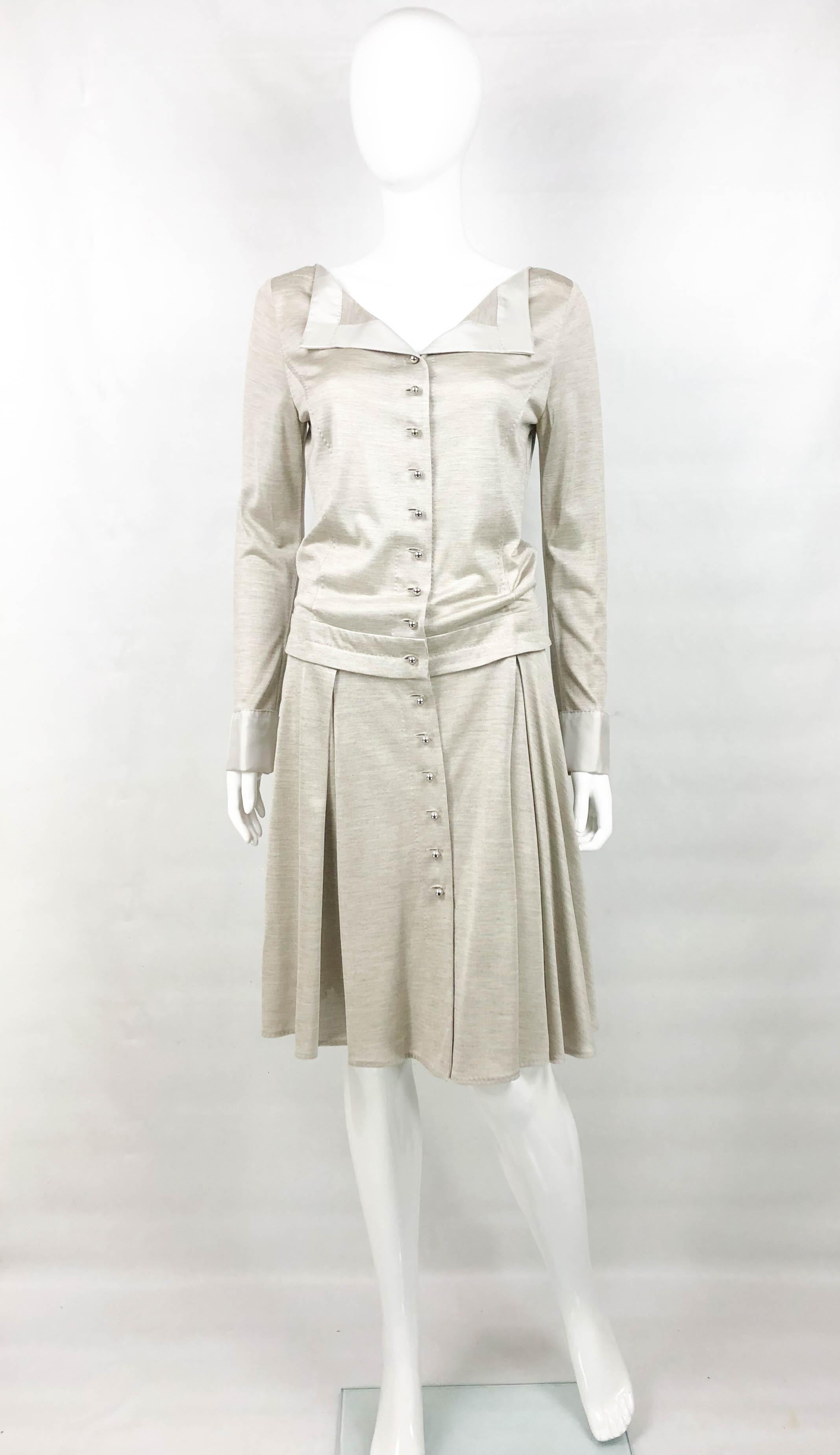 This stylish shirt dress by Louis Vuitton is made in silk jersey. With long sleeves and dropped waist, it hovers at knee height. The cuffs and lapel are made in silk. The silver-tone buttons are round and read Louis Vuitton. The cuffs come adorned
