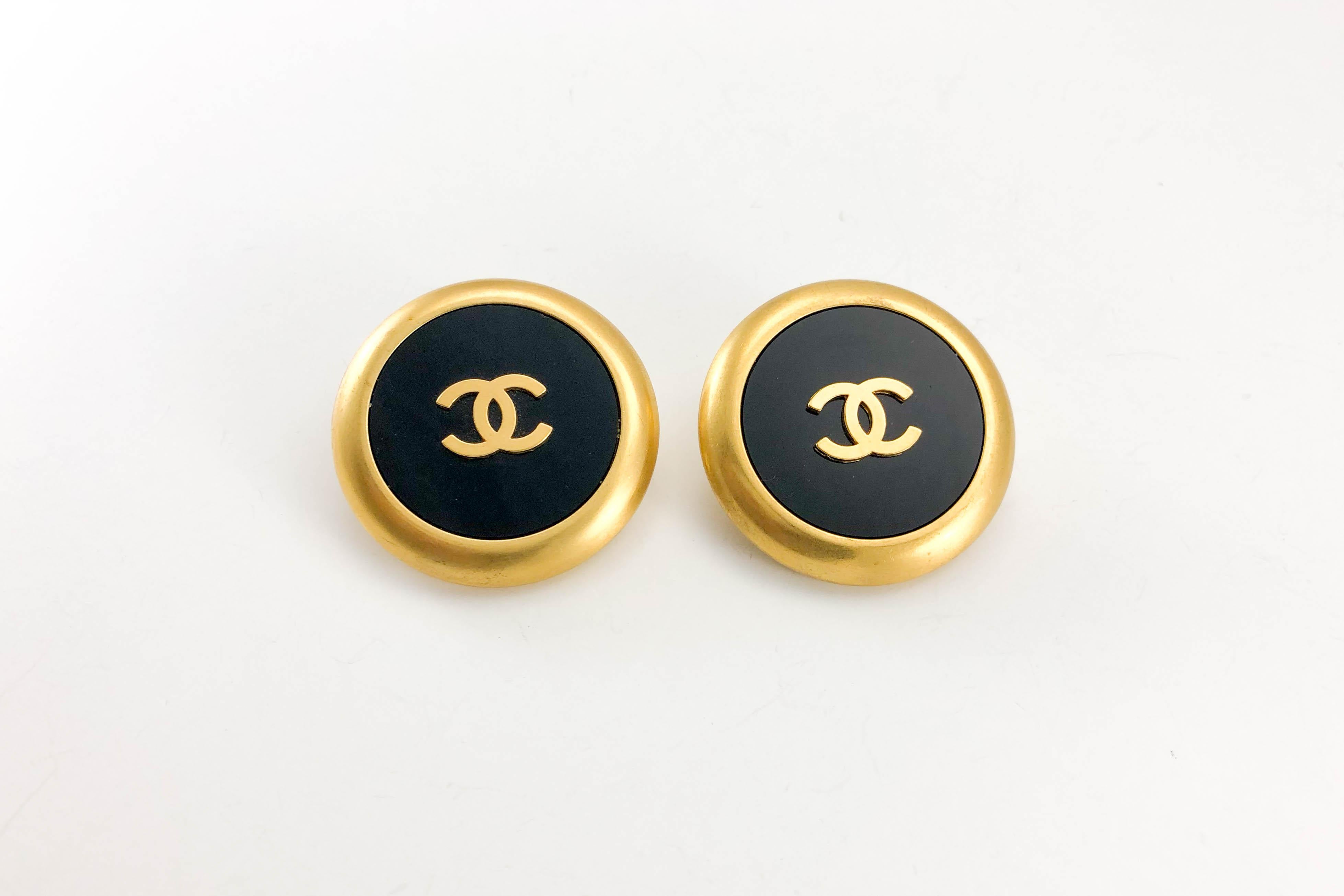 Vintage Chanel Large Black and Gold Logo Clip-on Earrings. These fabulous earrings by Chanel date back from 1992. Made in gilt metal and black resin, these large round earrings feature the iconic ‘CC’ logo in the centre. Chanel signed on the back. A